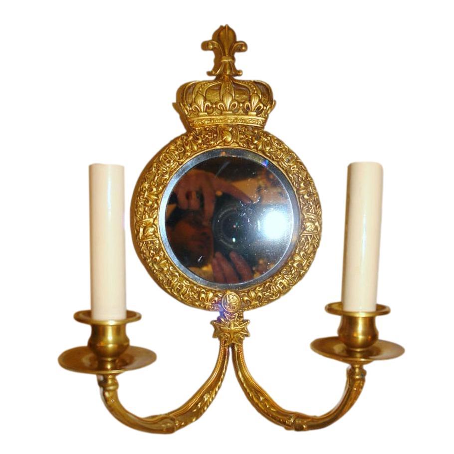 Paire d'appliques françaises en bronze fin à dos de miroir, datant des années 1920, avec des détails de couronne et de croix et une patine d'origine.

Mesures :
Hauteur : 12