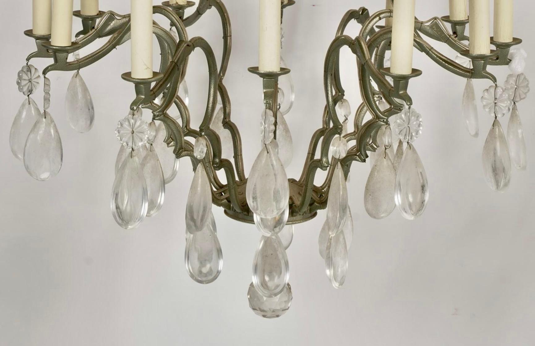 Pair of French Bronze Patinated Rock Crystal Chandeliers. Each features genuine rock crystals with a central orb supported by a bronze Patinated wrought iron frame.