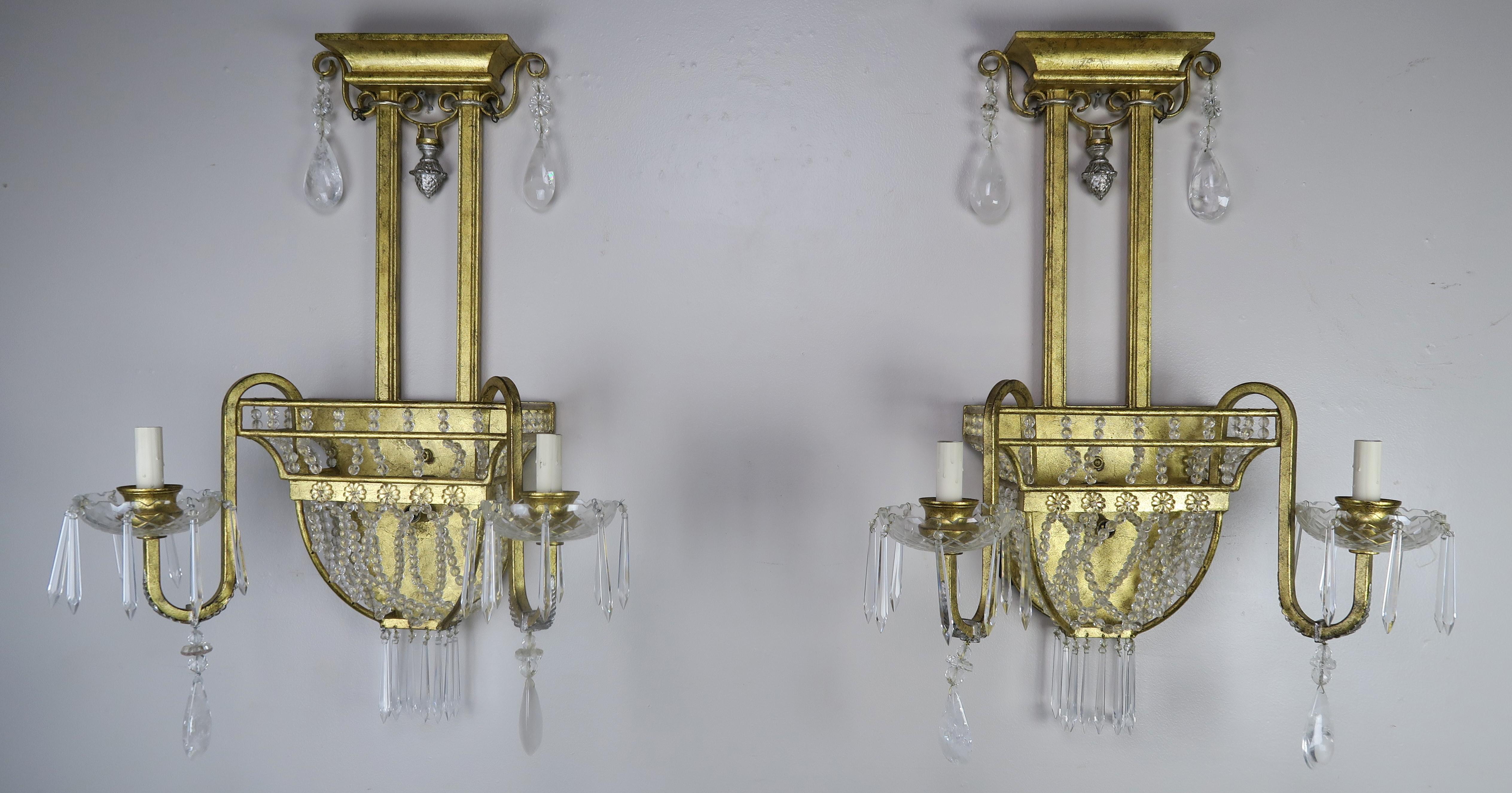 Pair of early 20th century 2-light cast bronze and rock crystal sconces. The sconces are detailed with strands of tiny crystal beads that create an 