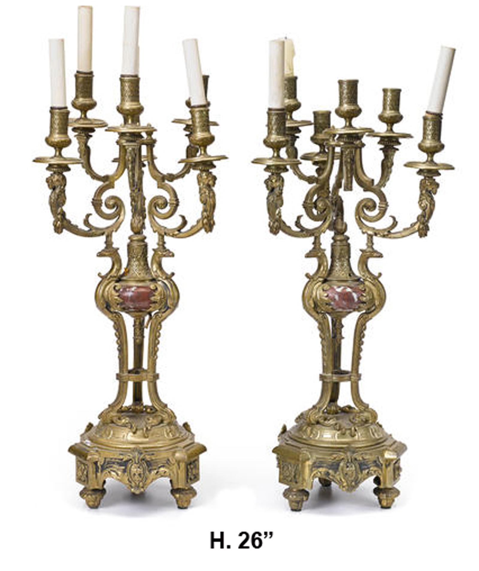 Impressive pair of French Louis XV style gilt bronze and rouge marble six light candelabra,
19th century.

Each candelabra issuing five gilt bronze arms, beginning in scrolling stems and terminating in a dish pan and candleholder, over a tri-form