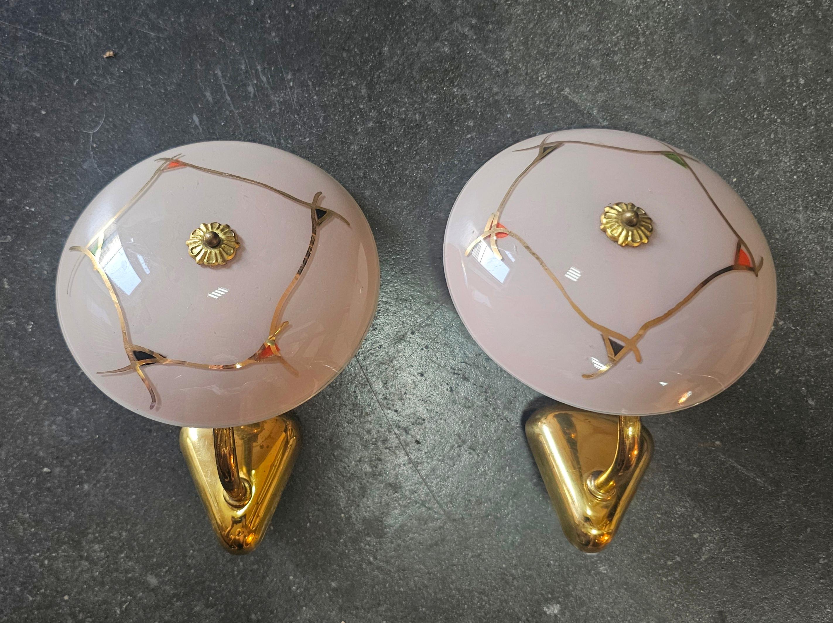 In this listing you will find a pair of very rare and extremely elegant sconces done in French gold plated bronze, with powder pink glass shades. They feature beautiful floral elements and are a true eye-catchers, despite their small size. Made in