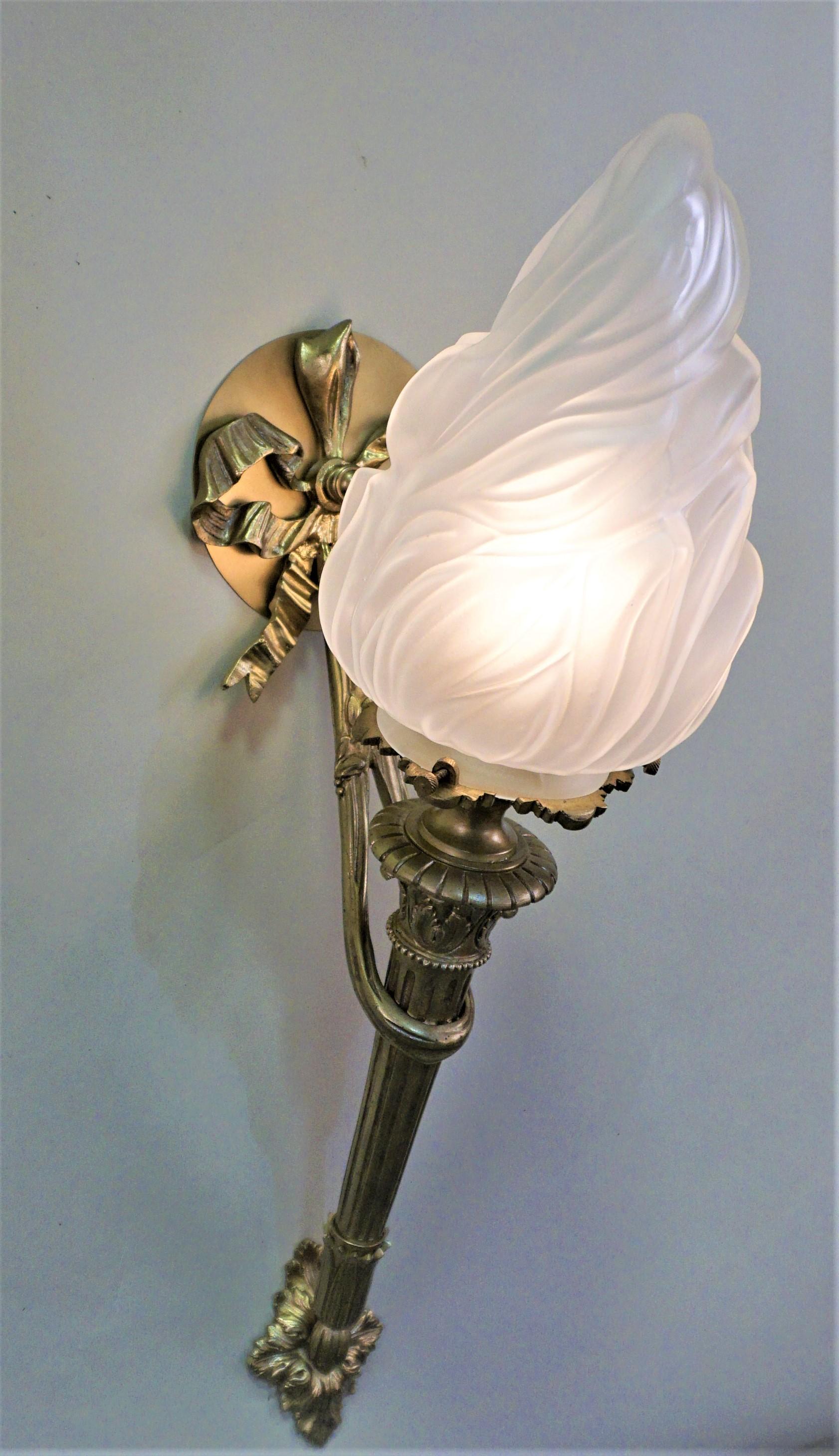 Pair of bronze torchiere wall sconce with flame shape glass shades.
