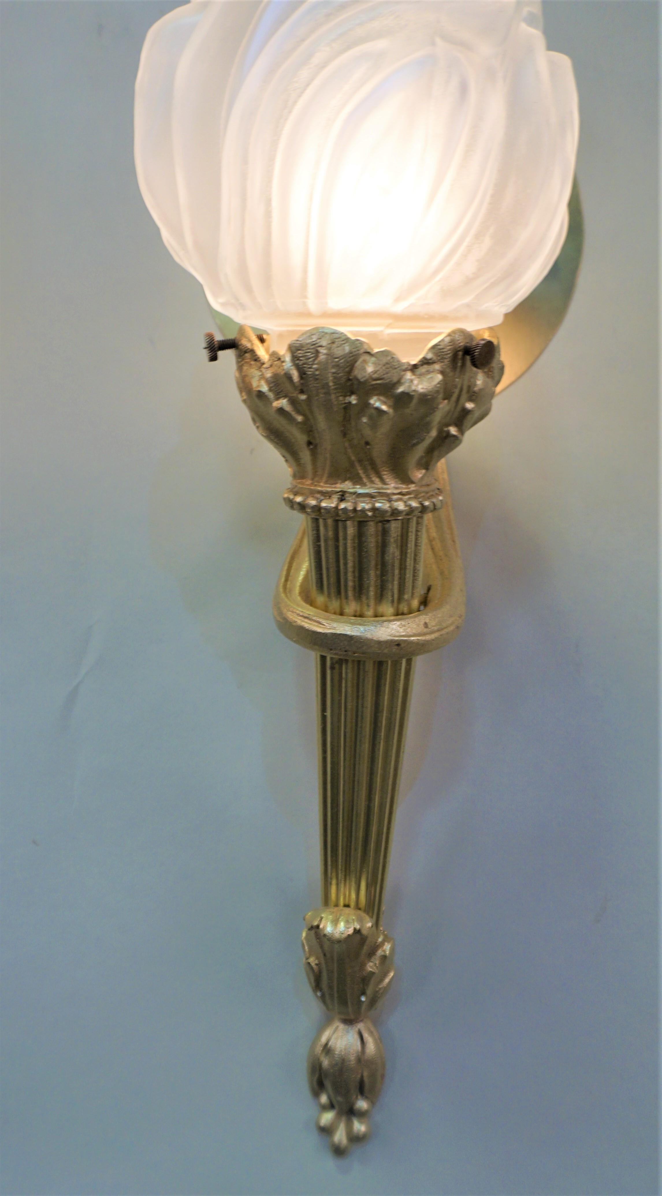 Pair of classical bronze torchiere wall sconce with flame shape glass shades.