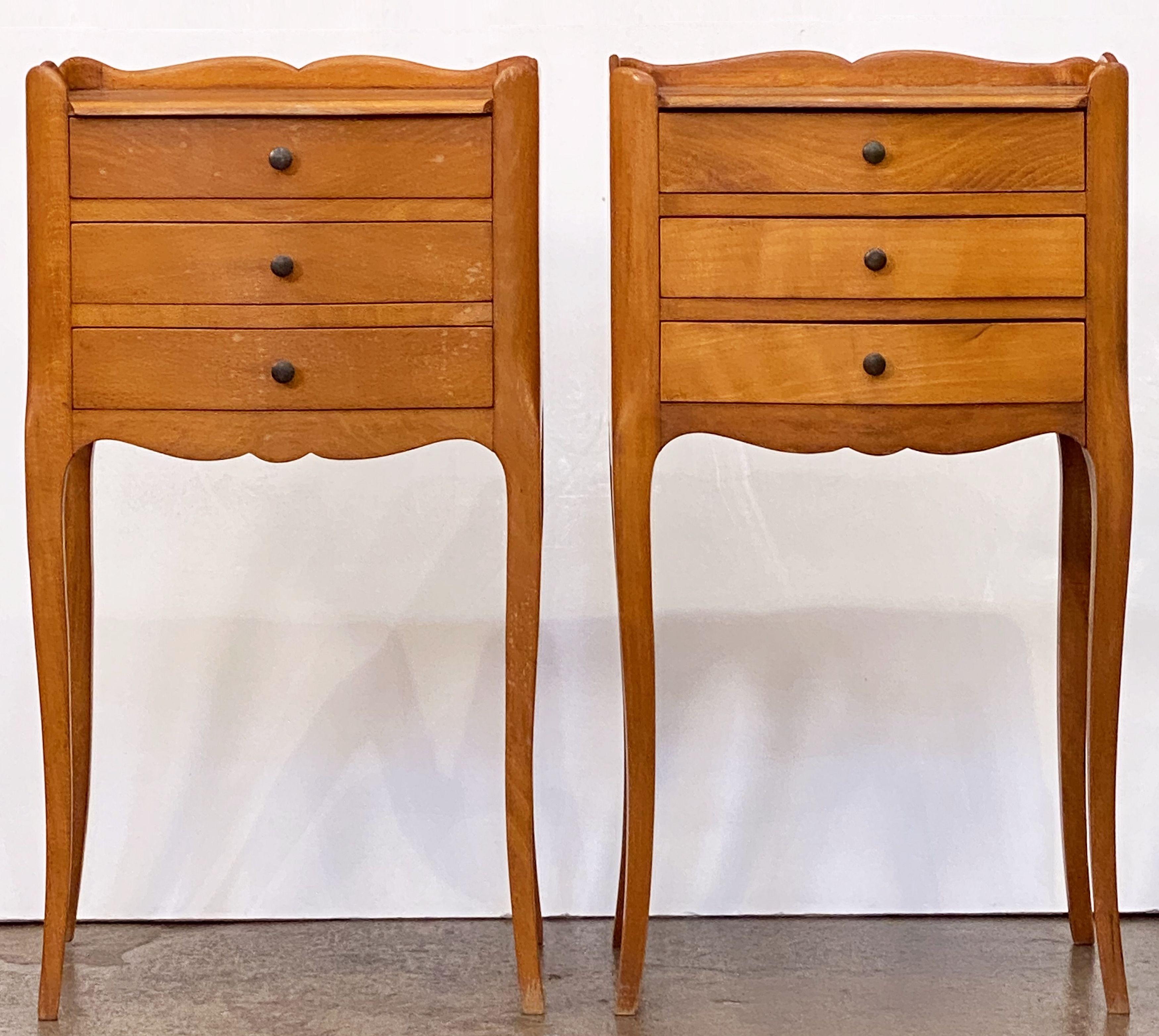 A fine pair of French bedside end tables or nightstands - each Stand featuring a scalloped edge gallery over a frieze of three drawers with brass pulls, apron bottom, and set upon four tapering cabriole legs.

Priced as a pair - $3895 the pair.