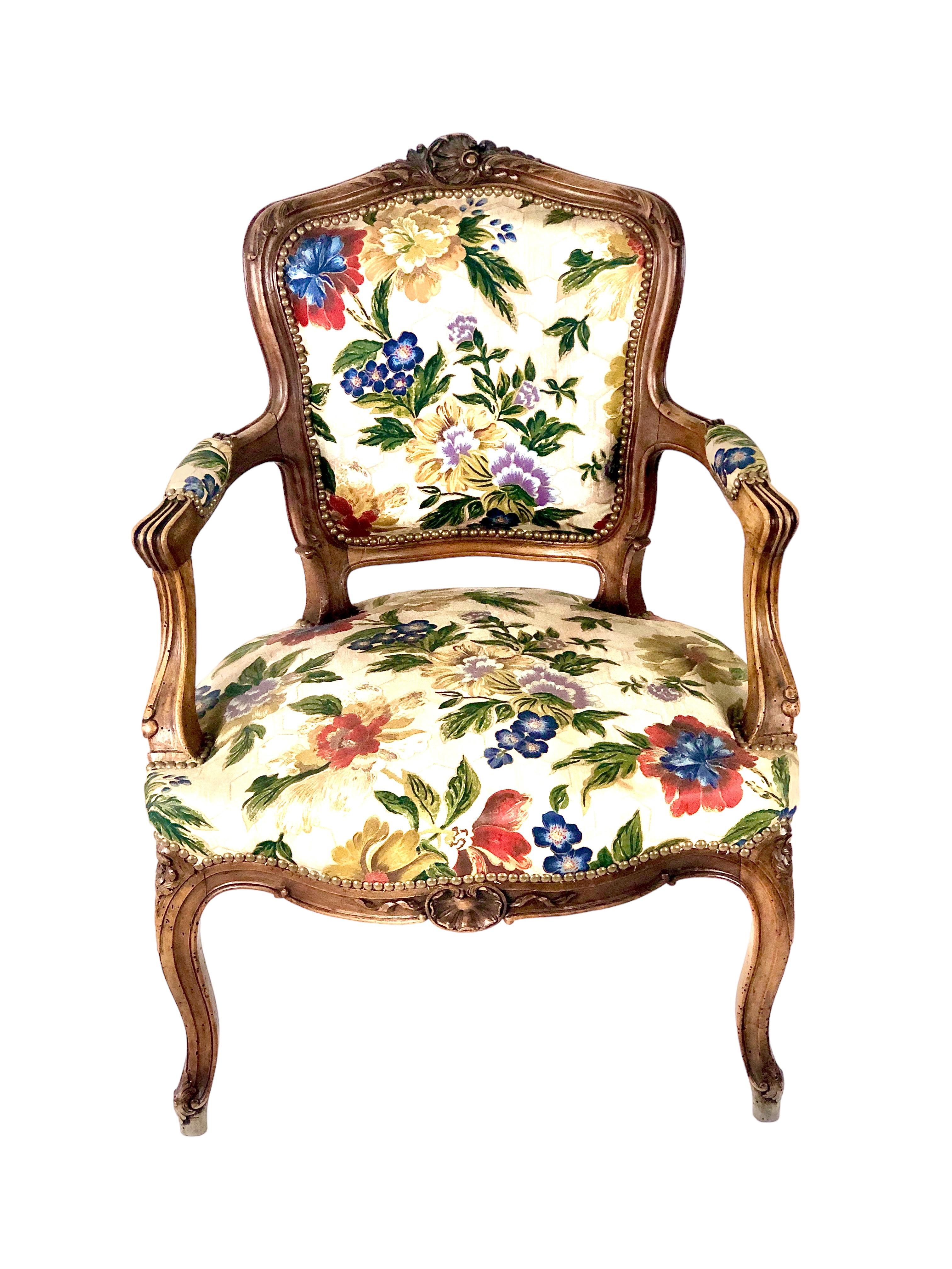 A pair of late 19th century Louis XV style, solid walnut, French cabriolets armchairs (Fauteuils Cabriolets), upholstered in a gorgeous fabric. The generous, wide proportions of these elegantly carved and moulded elegant armchairs were designed to