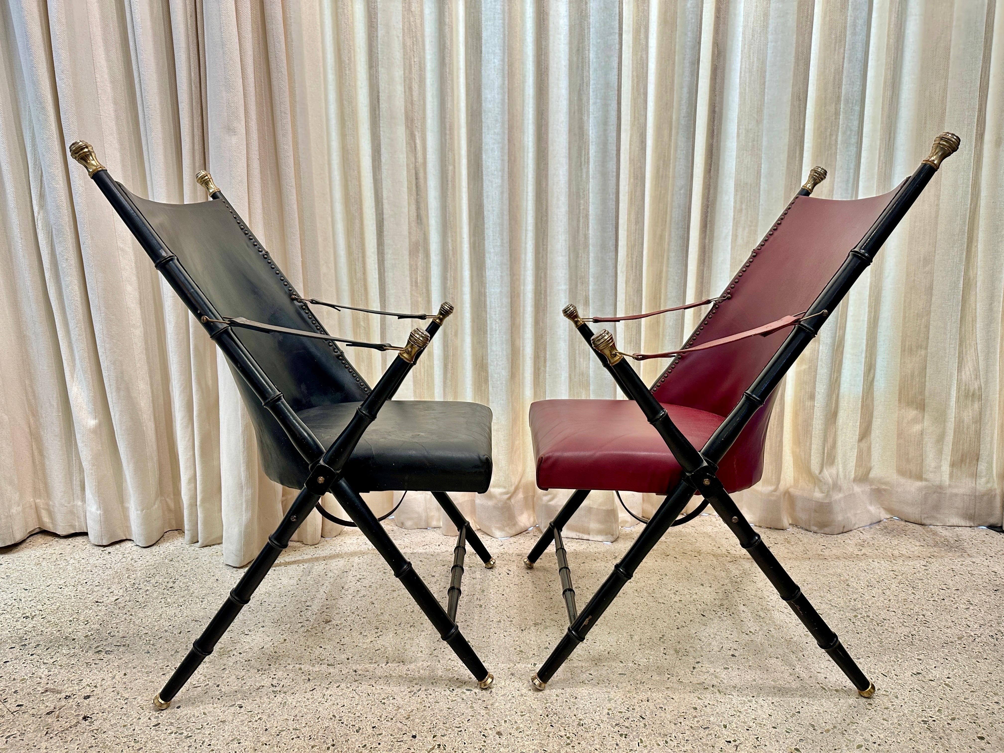 These wonderfully authentic pair of French Campaign-Style Leather Folding Chairs with Faux-Bamboo Frames in red and black.  Featuring brass caps to feet and finials.  Leather is ALL original and although a bit worn, still VERY usable and comfortable