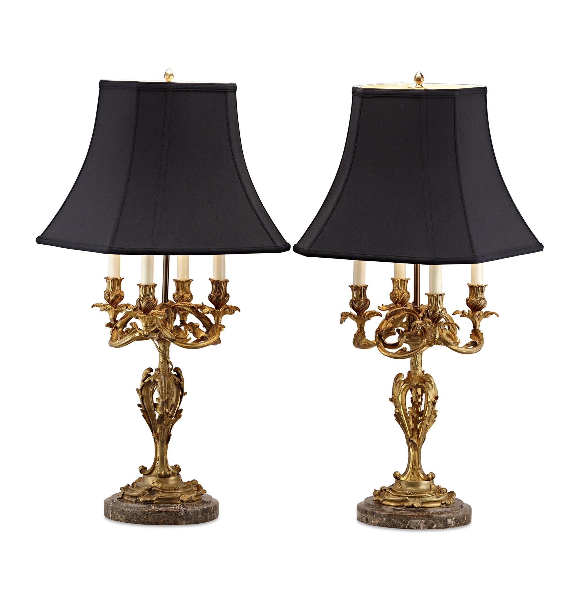 Coppia di lampade a candelabro
20° secolo

Questa coppia di lampade a candelabro francesi incarna la raffinata eleganza del design Luigi XV. Ognuno di essi presenta un corpo in ormolu fuso in modo intricato con un motivo a volute in stile rococò che