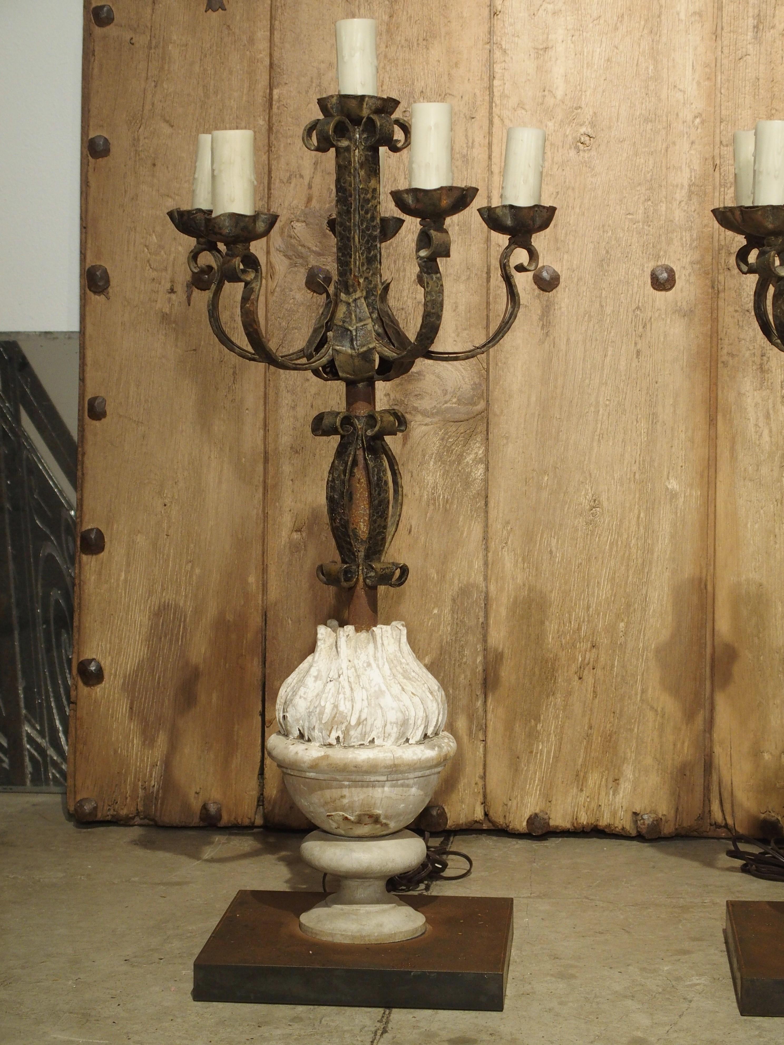 Made from hand wrought iron and repurposed antique elements, this pair of French candelabra lamps has a total of six sockets and a total height of 38 inches. The light of the central column rises above the surrounding lights atop the five curled
