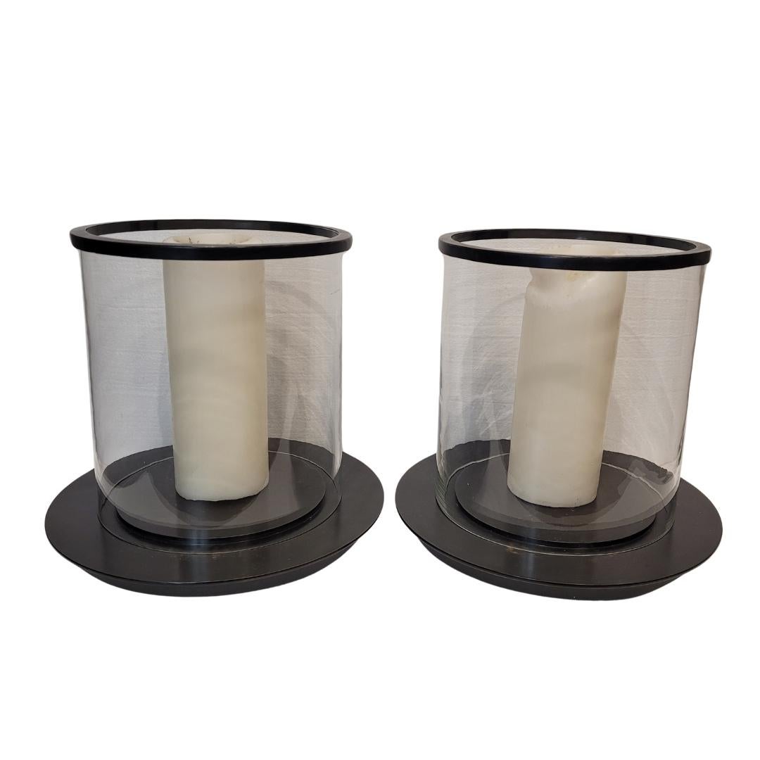Pair of beautiful French candle holders, photophores, candlesticks, glass, and black metal
Exceptional pair of cylindrical candle holders or candlesticks with a glass shade, black  metal base, and ornamental metal finial or rim. The base is circular