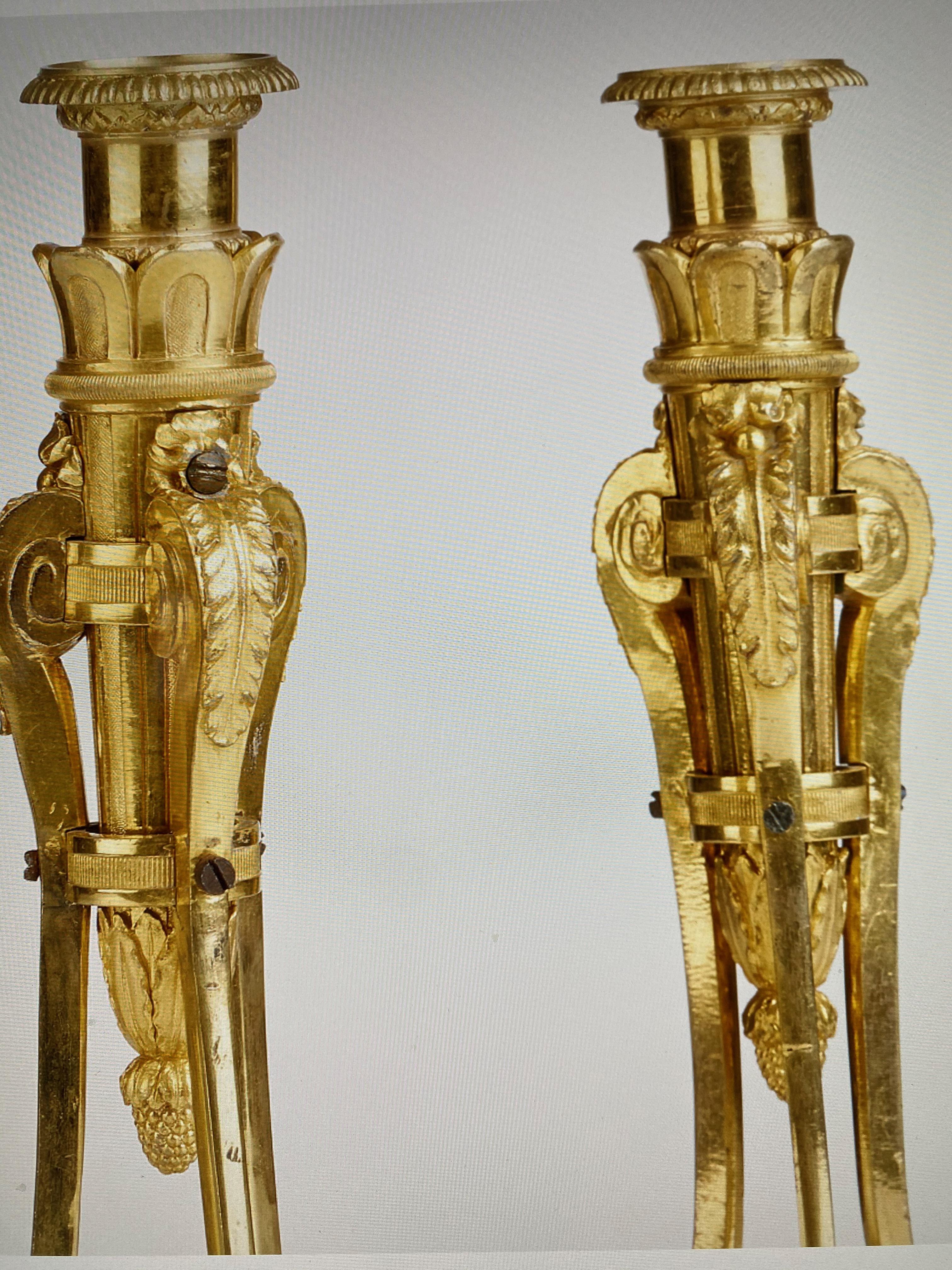 A pair of candlesticks of an unusual design. White marble and gilt bronce.