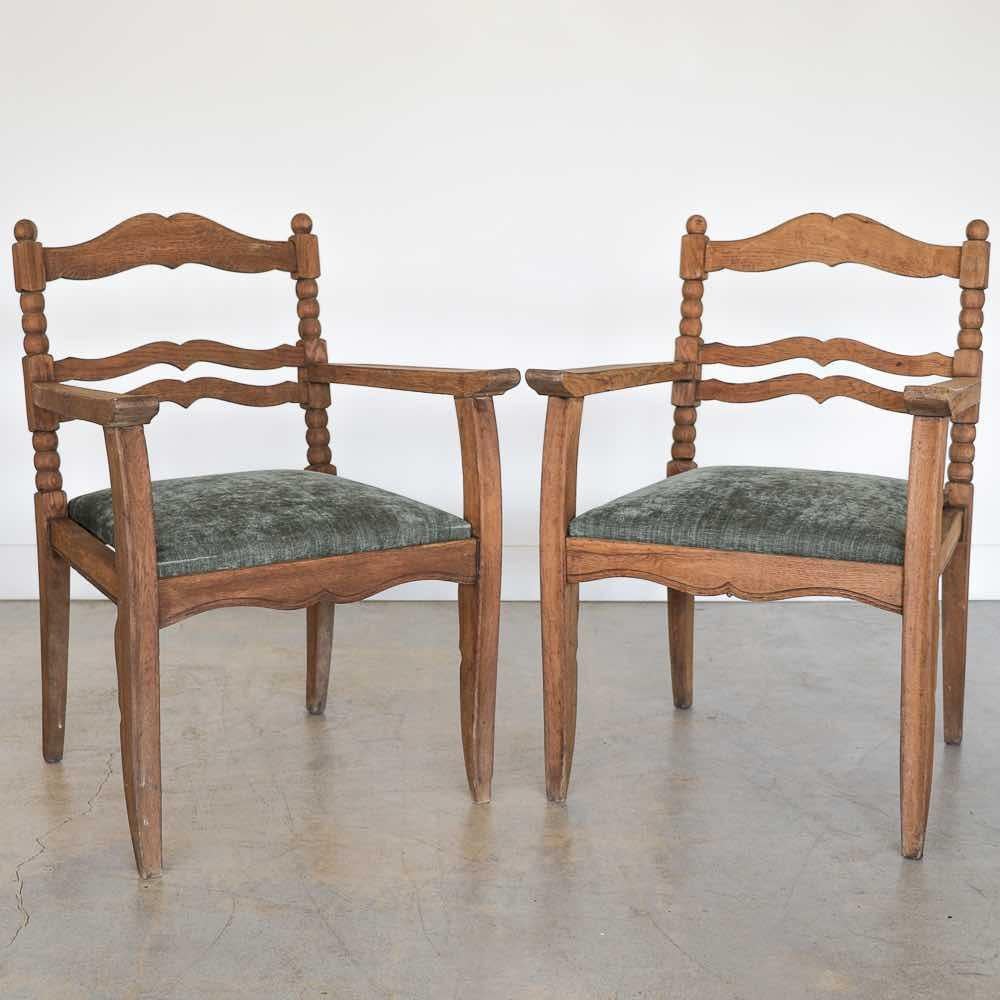 Incredible pair of carved oak armchairs from France, 1940s. Beautiful ornate carved wood chair frame with bobbin and scallop detail. Newly upholstered seats in a textured sage green chenille. Chair has removable seat. Original finish shows nice age