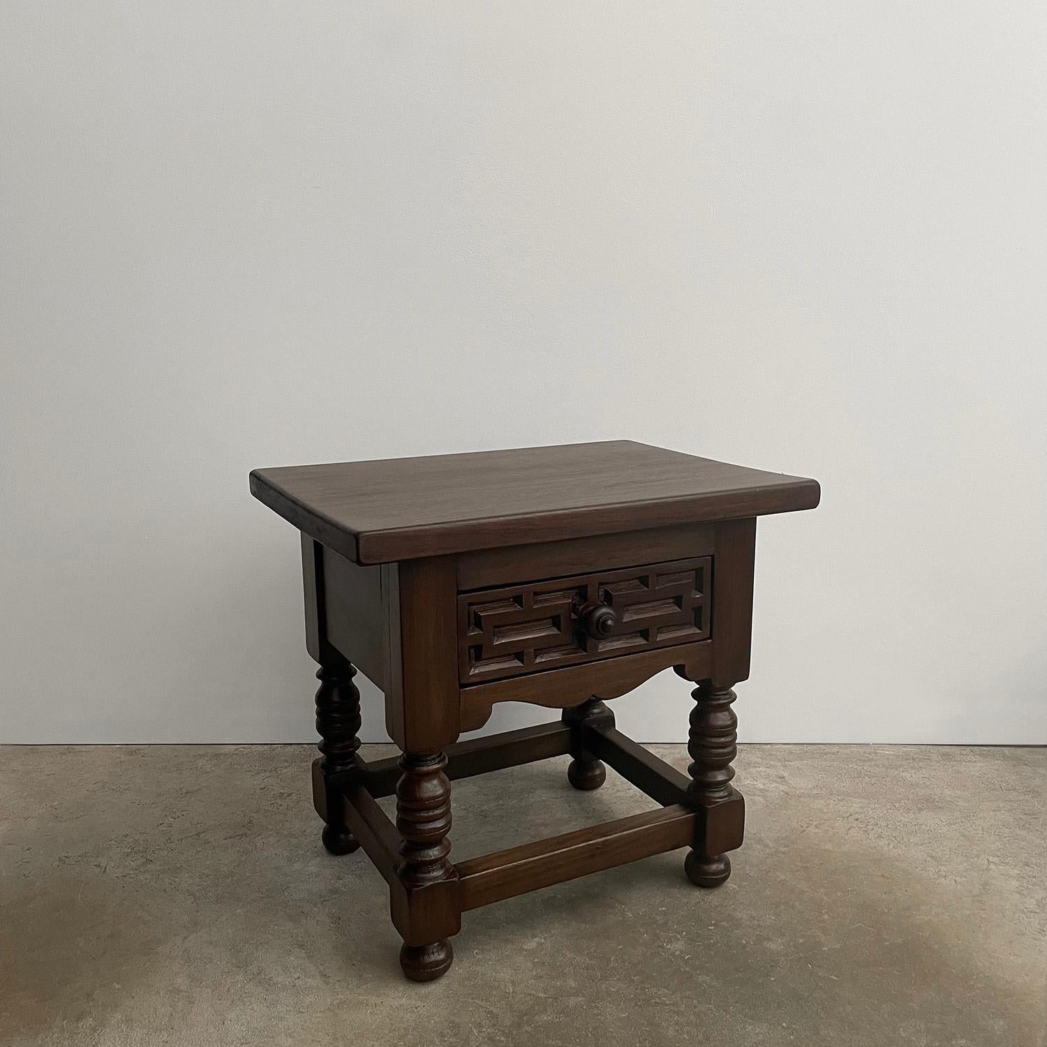 Pair of French carved oak end tables 
France, mid century 
Solid wood hand crafted artisanal piece 
Beautiful wood grain detail
This pair of tables are well constructed and heavy weight 
Each table has a single drawer which is accented with carved