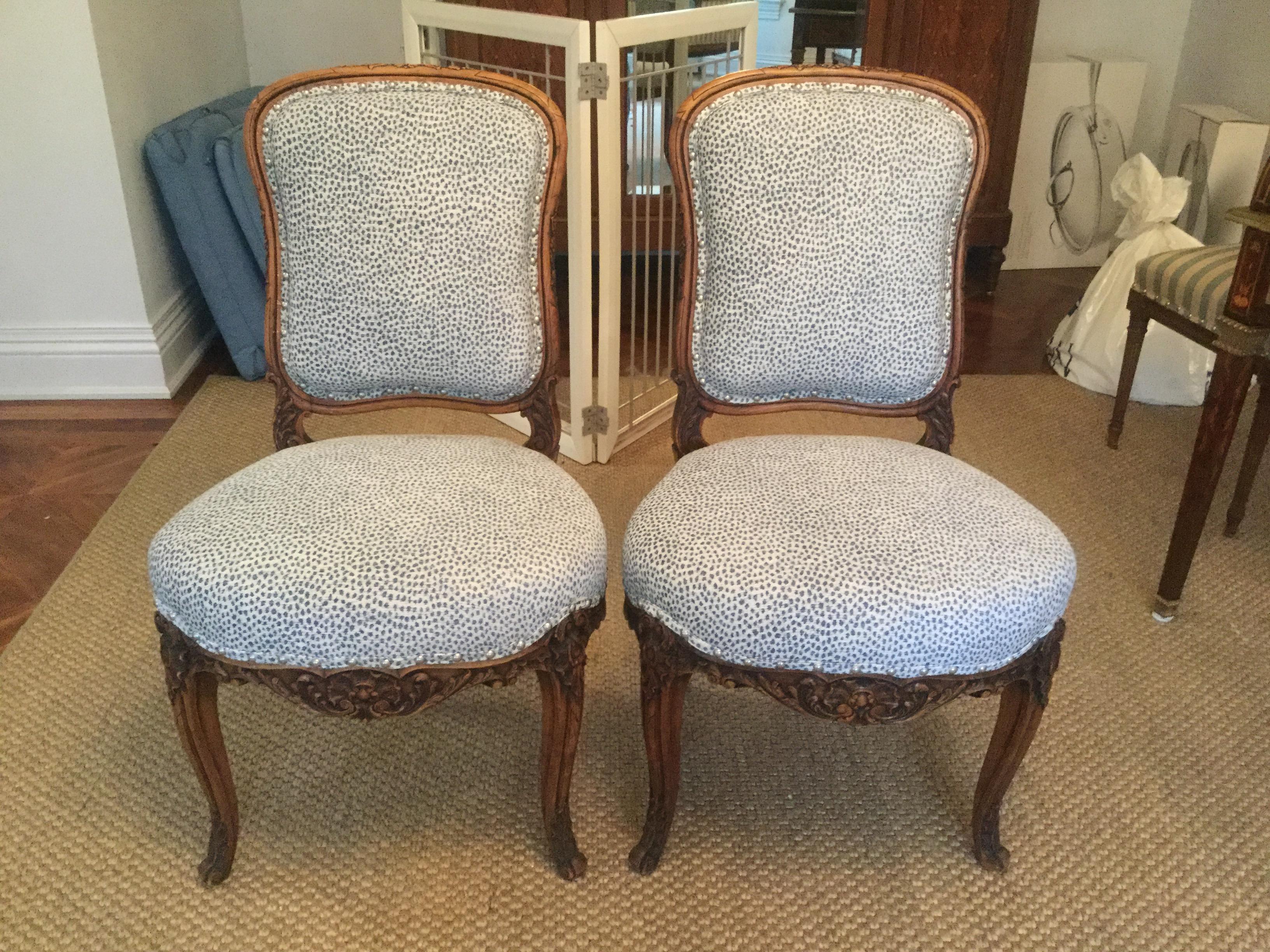 Stunning pair of late 19th century French side chairs. Made of walnut, these chairs feature a beautifully carved frame and new animal print velvet upholstery. These chairs are sturdy and have large seats for comfort. Silver nail-heads and