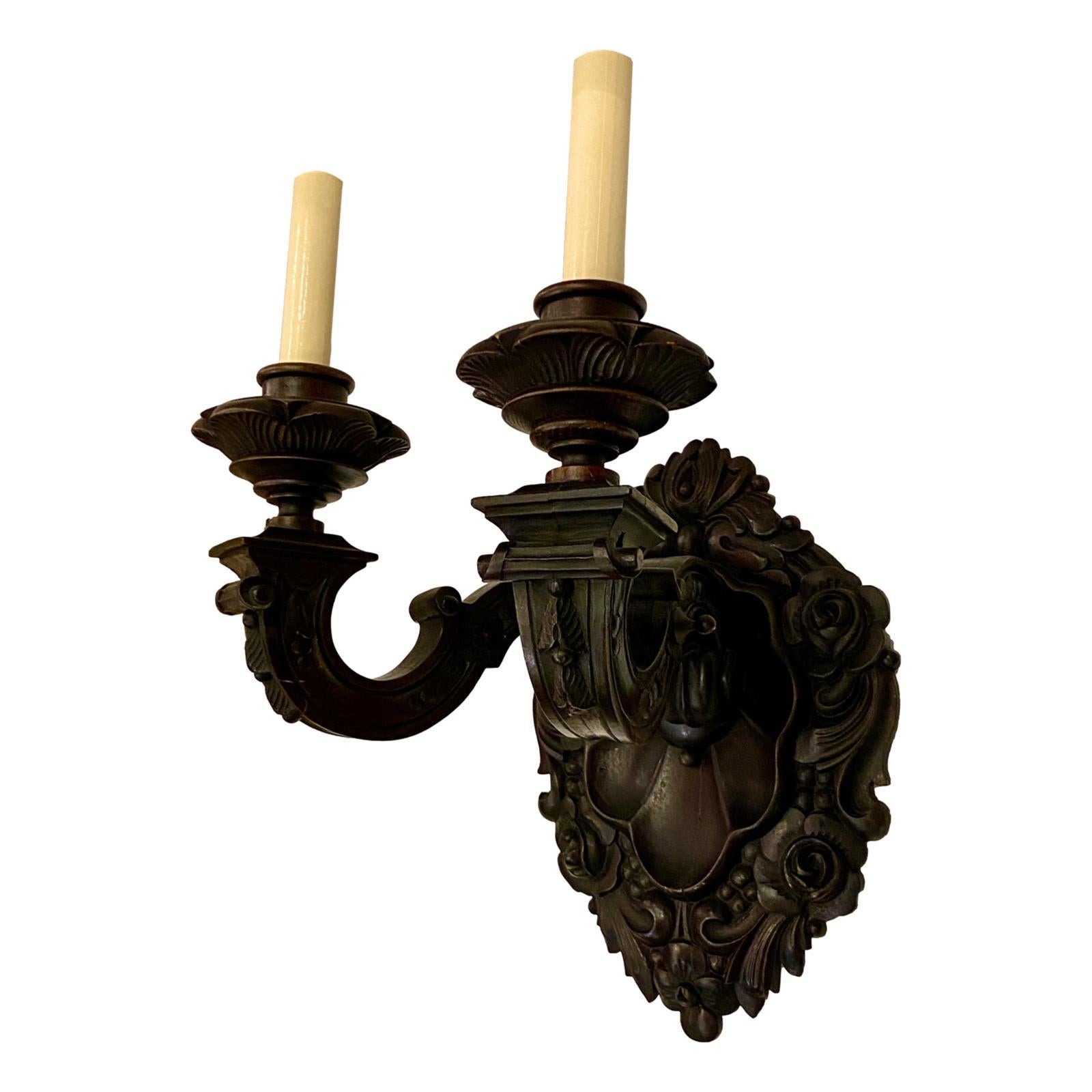 Pair of French circa 1920s double-light carved wood sconces with foliage and floral motif on body.

Measurements:
Height 11.5