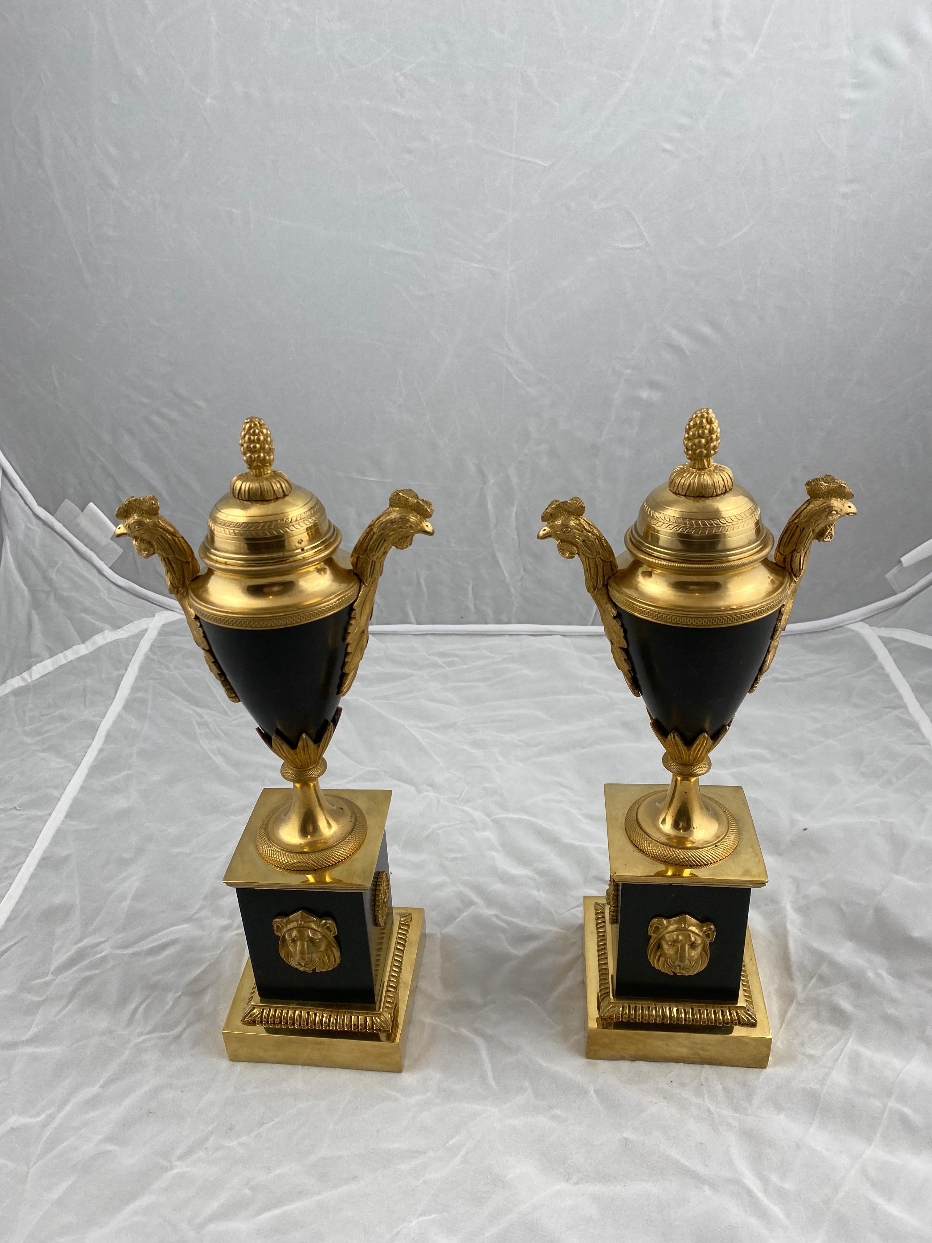 A pair of casolettes made of gilt and dark patinated bronze. The sides of the urn with decorated with heads of a cock. The symbol for France.