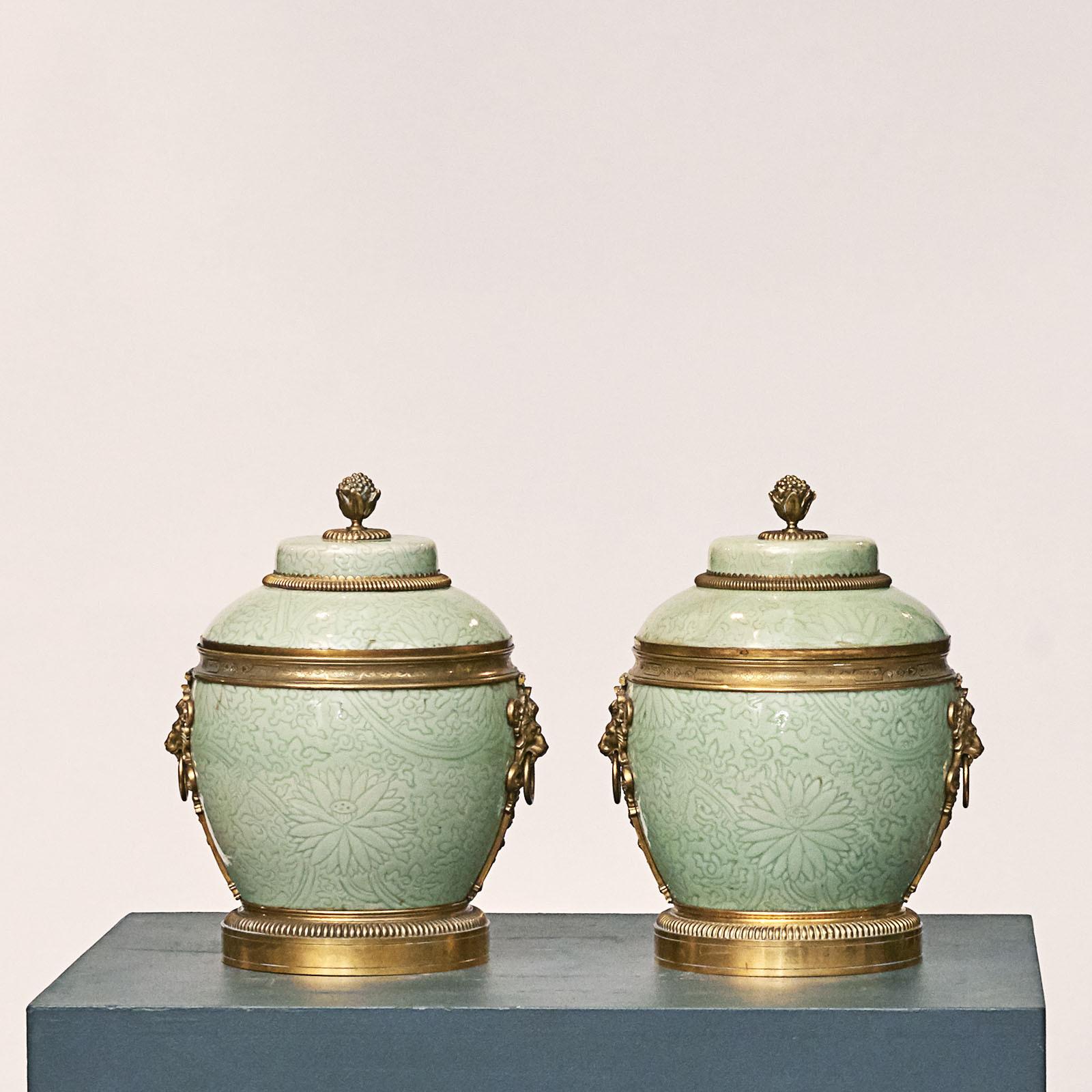 A pair of Regence gilt-bronze mounted celadon lidded vases, Qing dynasty, Kangxi (1662-1722), in the manner of Yuan dynasty, and circa 1720.
Each turquoise colored lidded vase / urn is made of Chinese glazed porcelain and features an Ormolu knob on