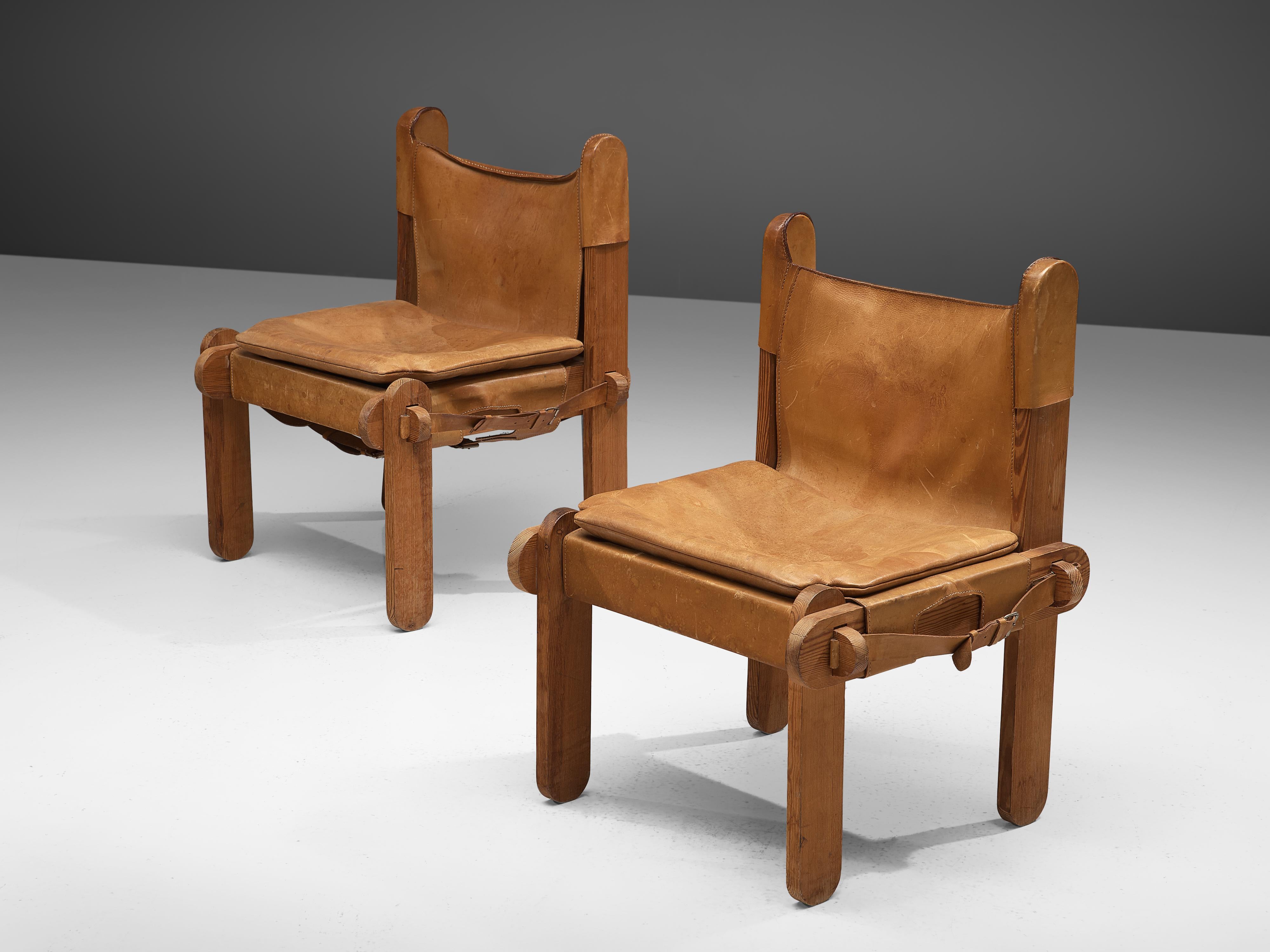 Side chairs, leather, pine, France, 1950s

These chairs are characterized by the patinated cognac leather that is adjusted to the wooden frame consisting of wooden slats with round ends. The warm colored leather is attached to the frame by straps