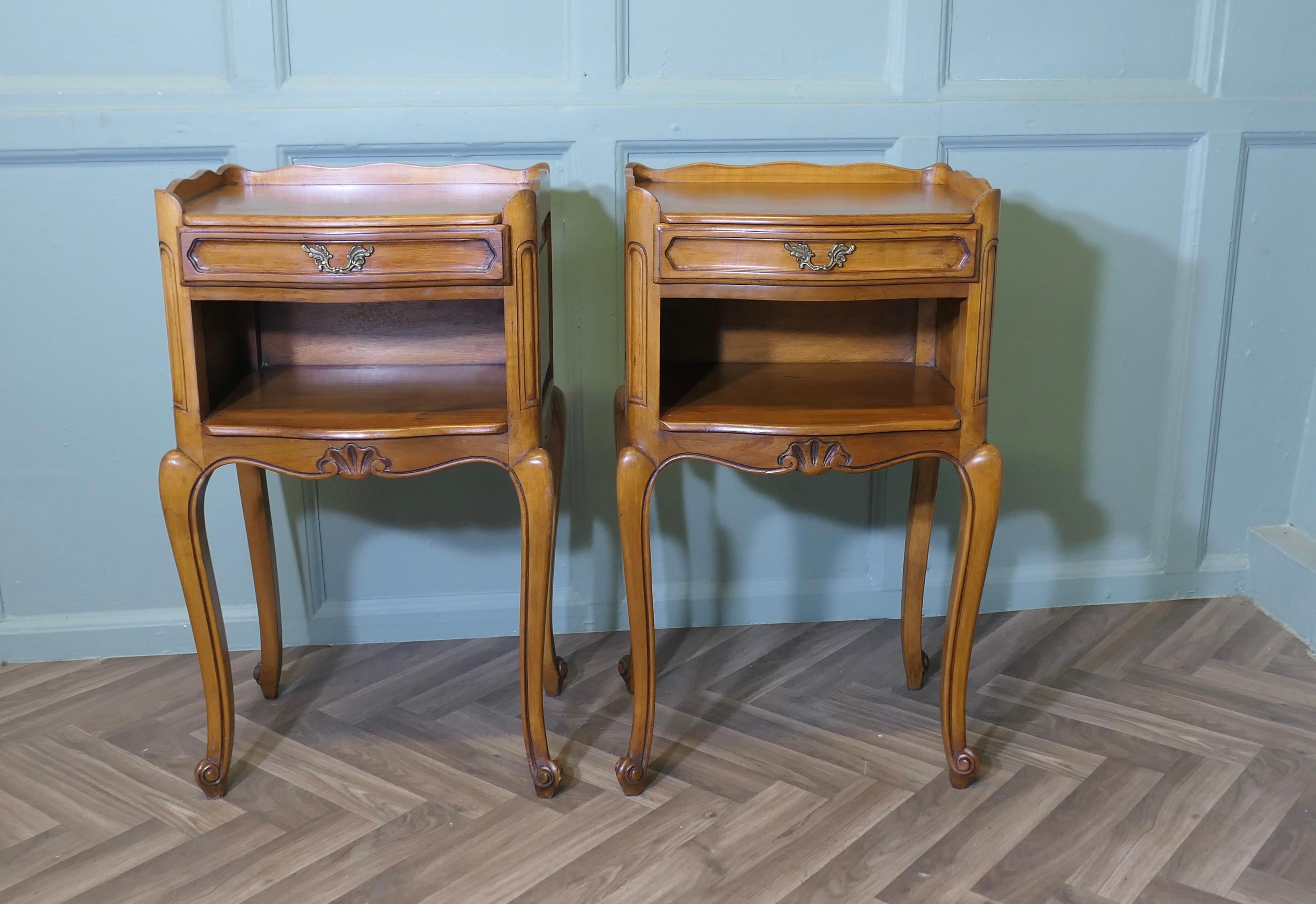 Paire de tables de chevet en cerisier français 

Il s'agit d'une jolie paire de chevets français en merisier, avec une galerie sur le dessus, un tiroir et une étagère à livres ouverte en dessous. Ils reposent sur de minces pieds cabriole, une paire