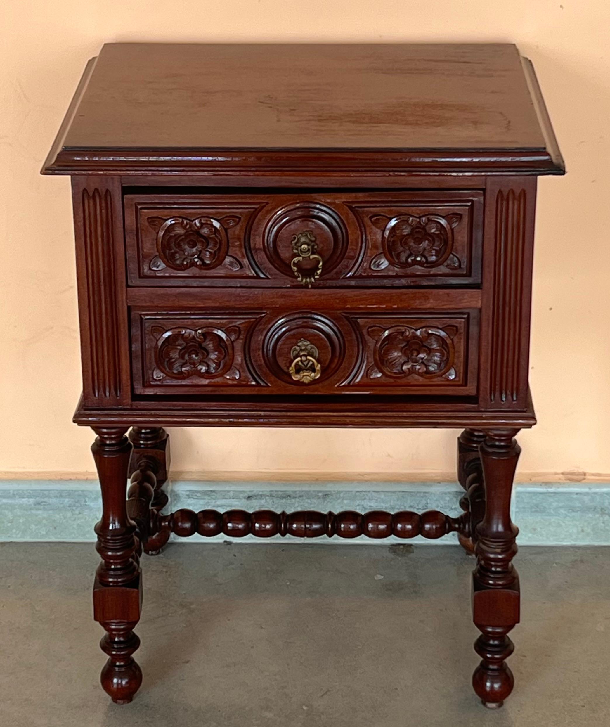 A French chestnut two-drawer commode from the late-19th century with ribbon-carved moldings and carved skirt. This petite French commode features a rectangular top with beveled edges, sitting above two exquisite drawers, each simply adorned with a