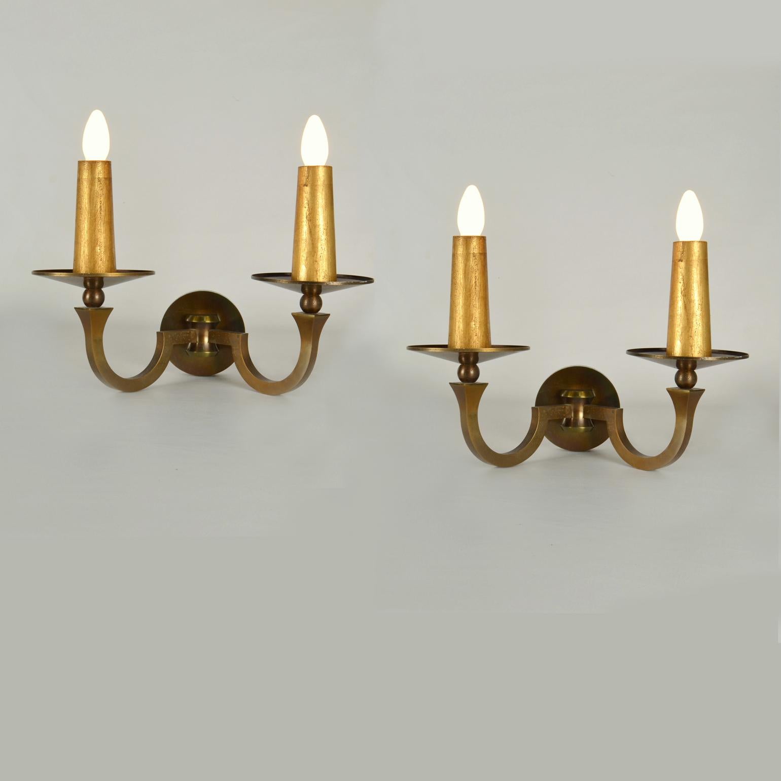 Pair of French Classical bronze and gild wood wall scones have scrolled-shaped arms in the style of the ancient Greek ionic columns. The arms are connected by a bronze sphere which is attached to a cupped back plate. Their symmetry evenly spaced