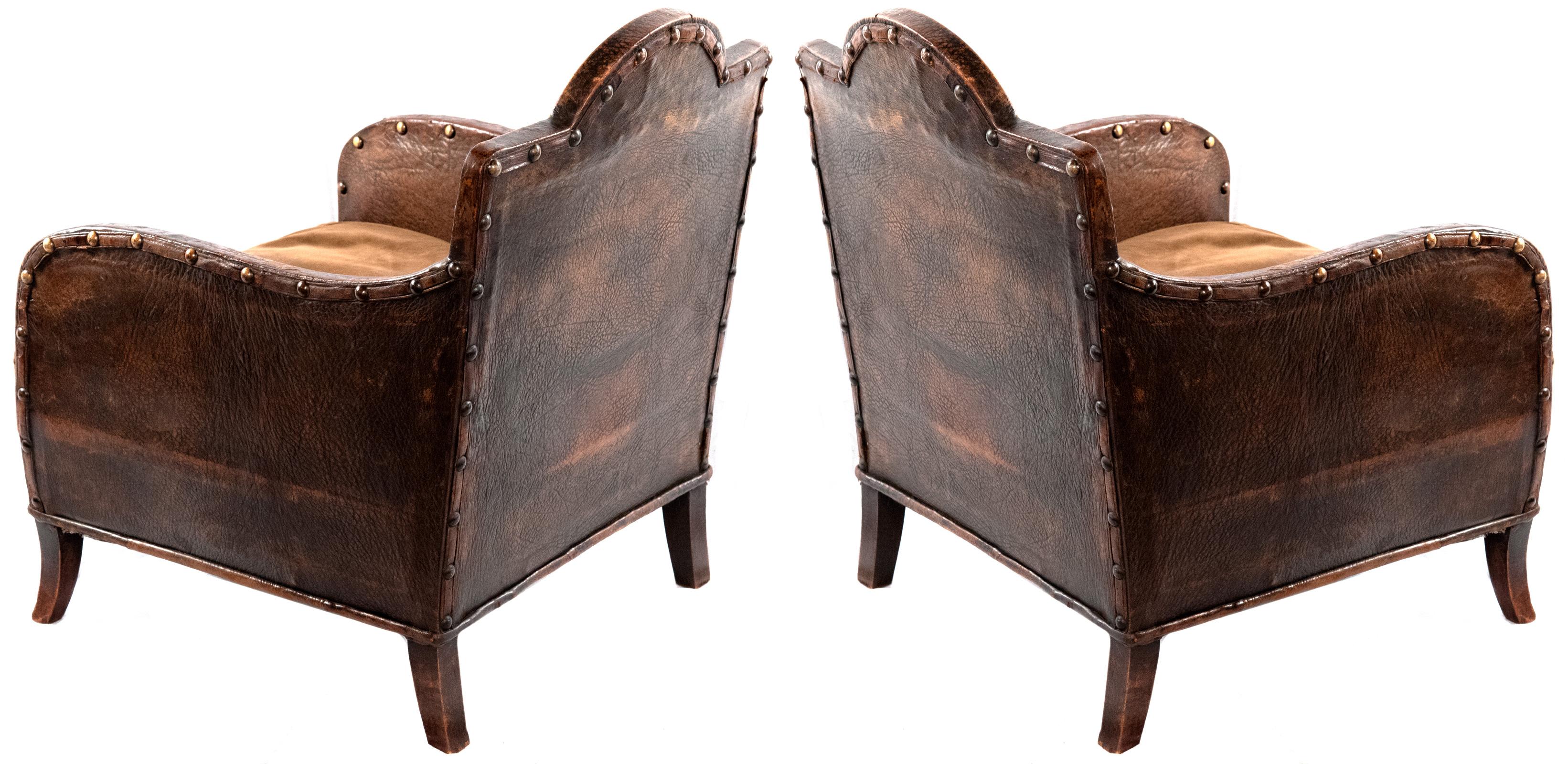 Two walrus leather chair with brass studs and sabered walnut legs.