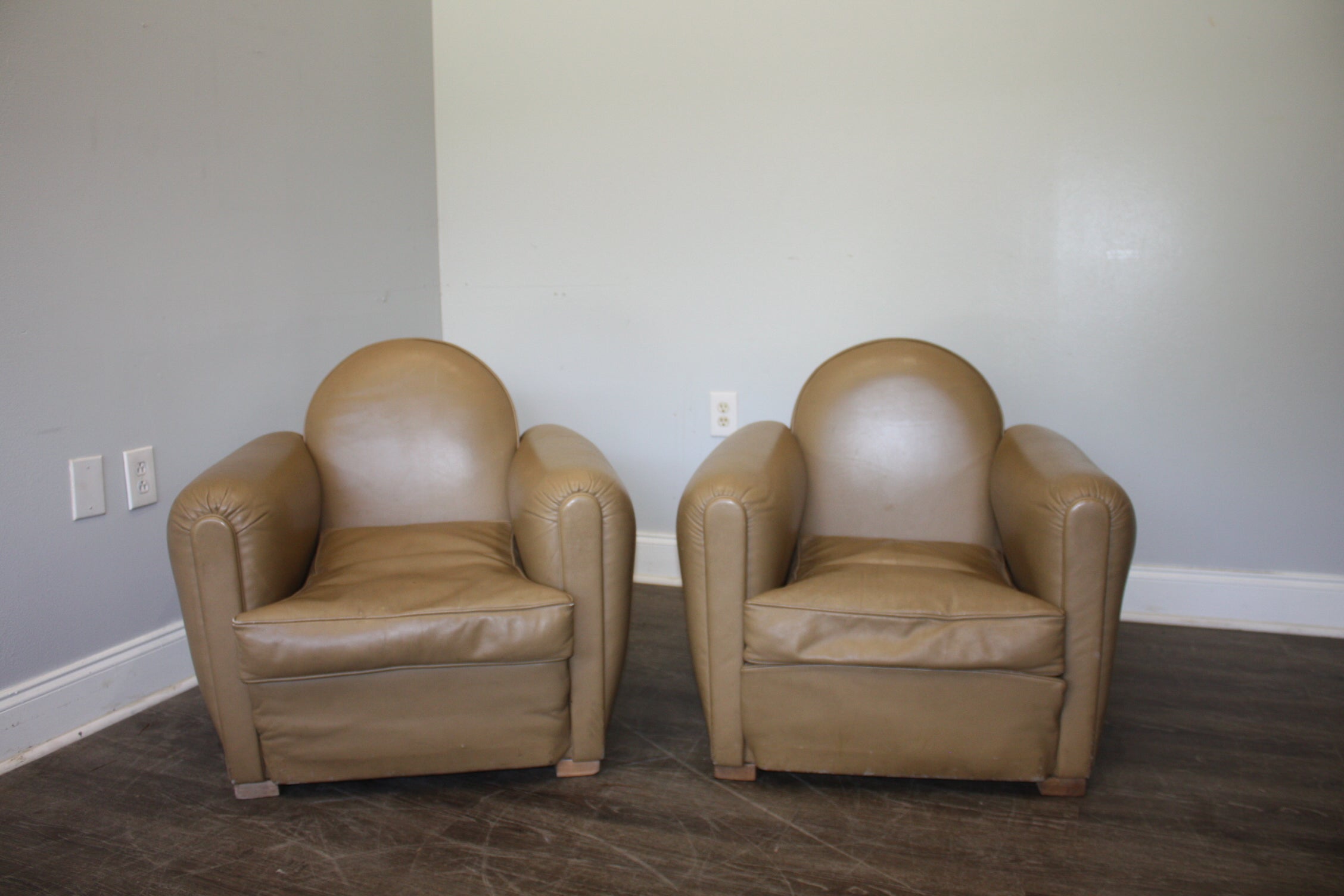 Those Club Chairs are small, ideal for a small room, very confortable and is made of beige/grey color leather.