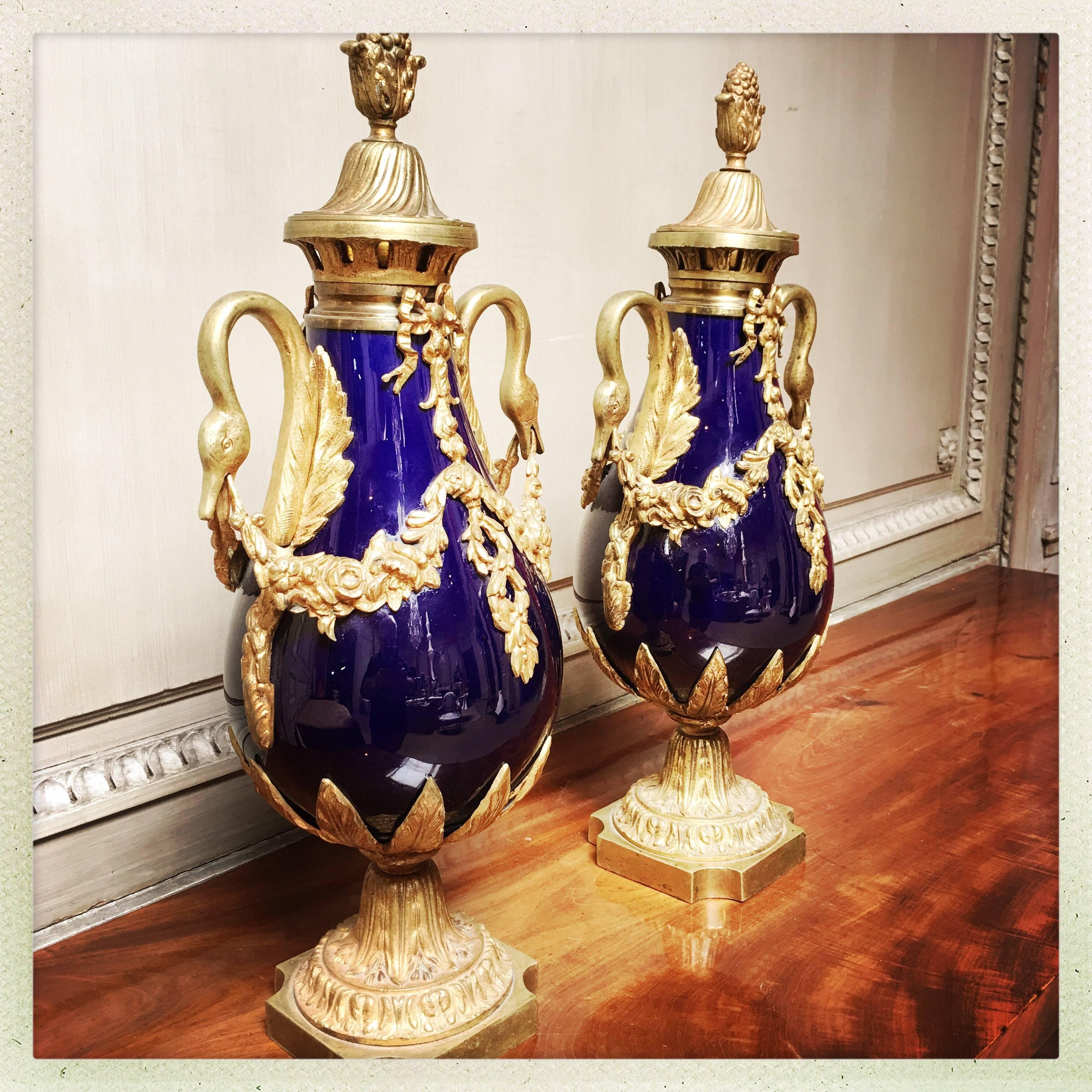 A pair of French cobalt blue porcelain and bronze mounted cassolettes in the Louis XVI style from the late 19th century.