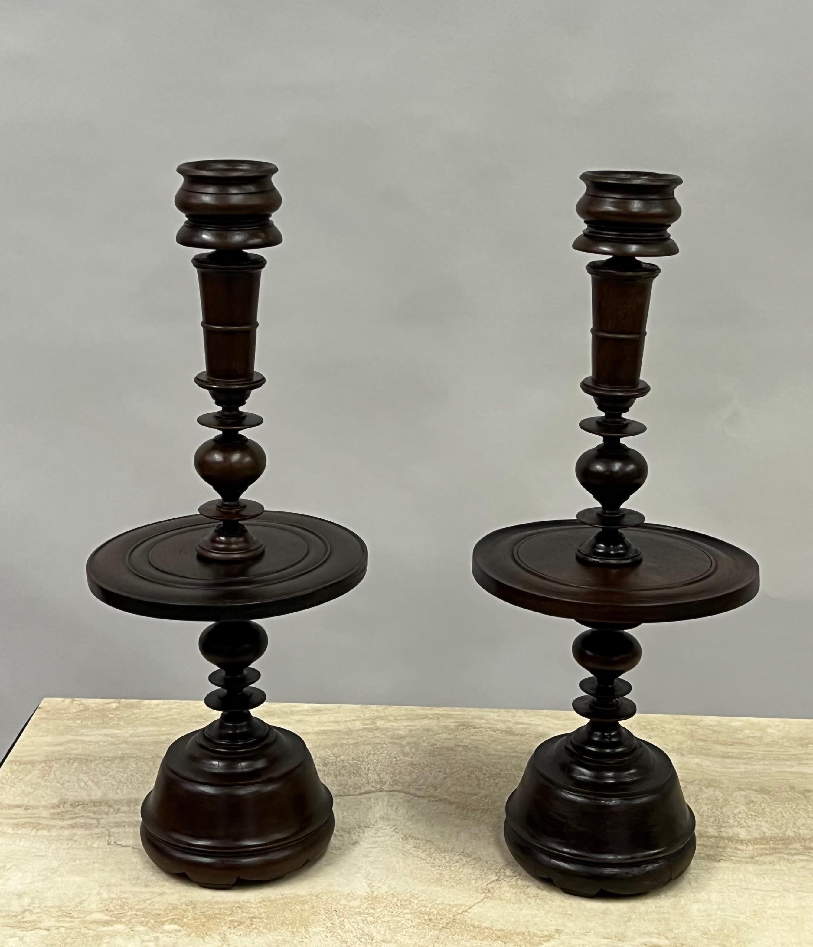 Rare, timeless and elegant pair of French Colonial table lamp bases or candelabras from the French colony of French Indochina also known a Indochine. The pieces are hand carved from Teak Wood into sumptuous forms and can be adapted to accommodate an