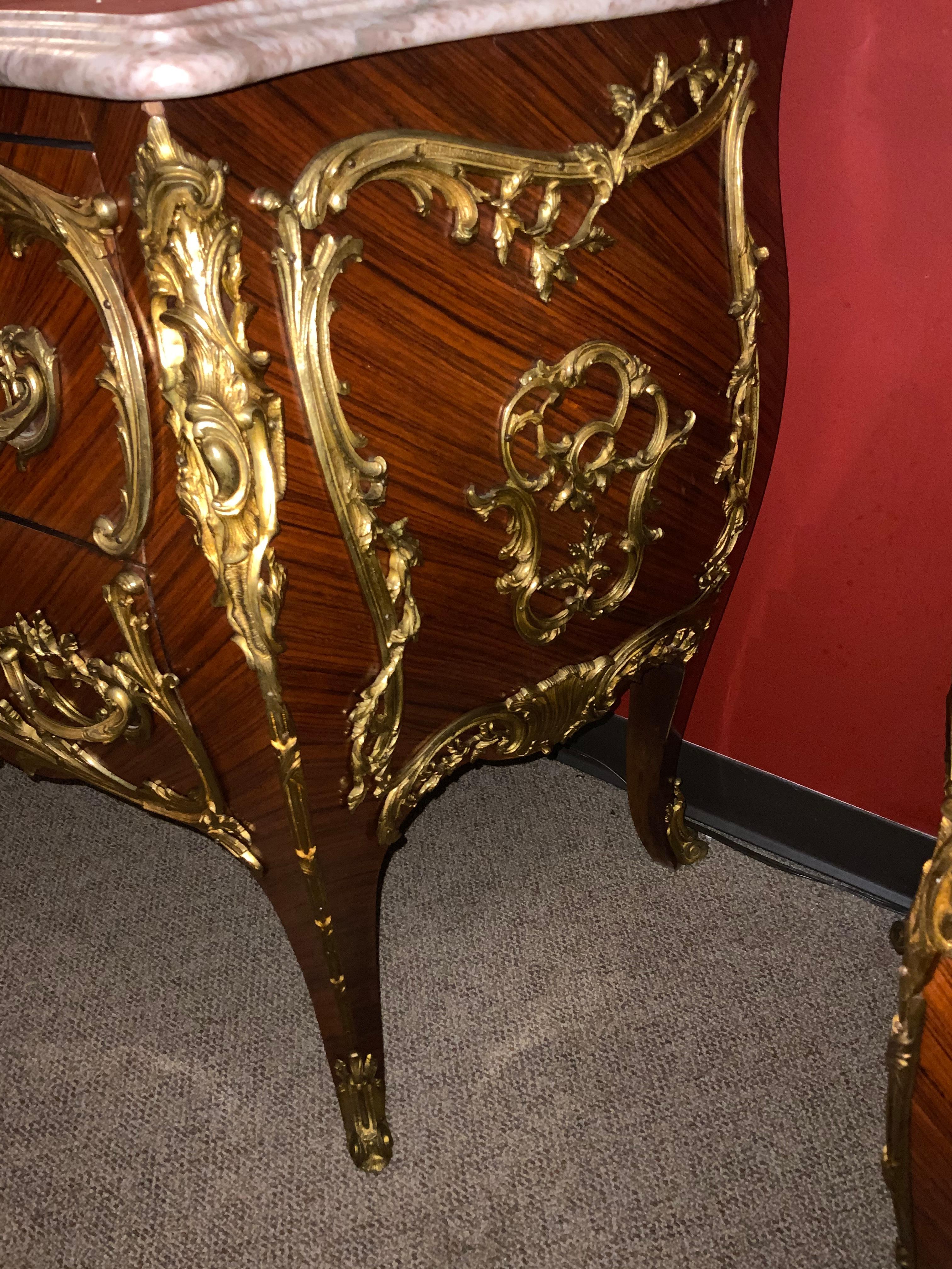 Pair of fine French commodes
with bronze dore mounts with original patina in brilliant hue
The cross matched  kingwood veneers exhibit  fine workmanship.
Pale cream marble with rose and Aubergine veining is without
Problems, breaks or chips. There