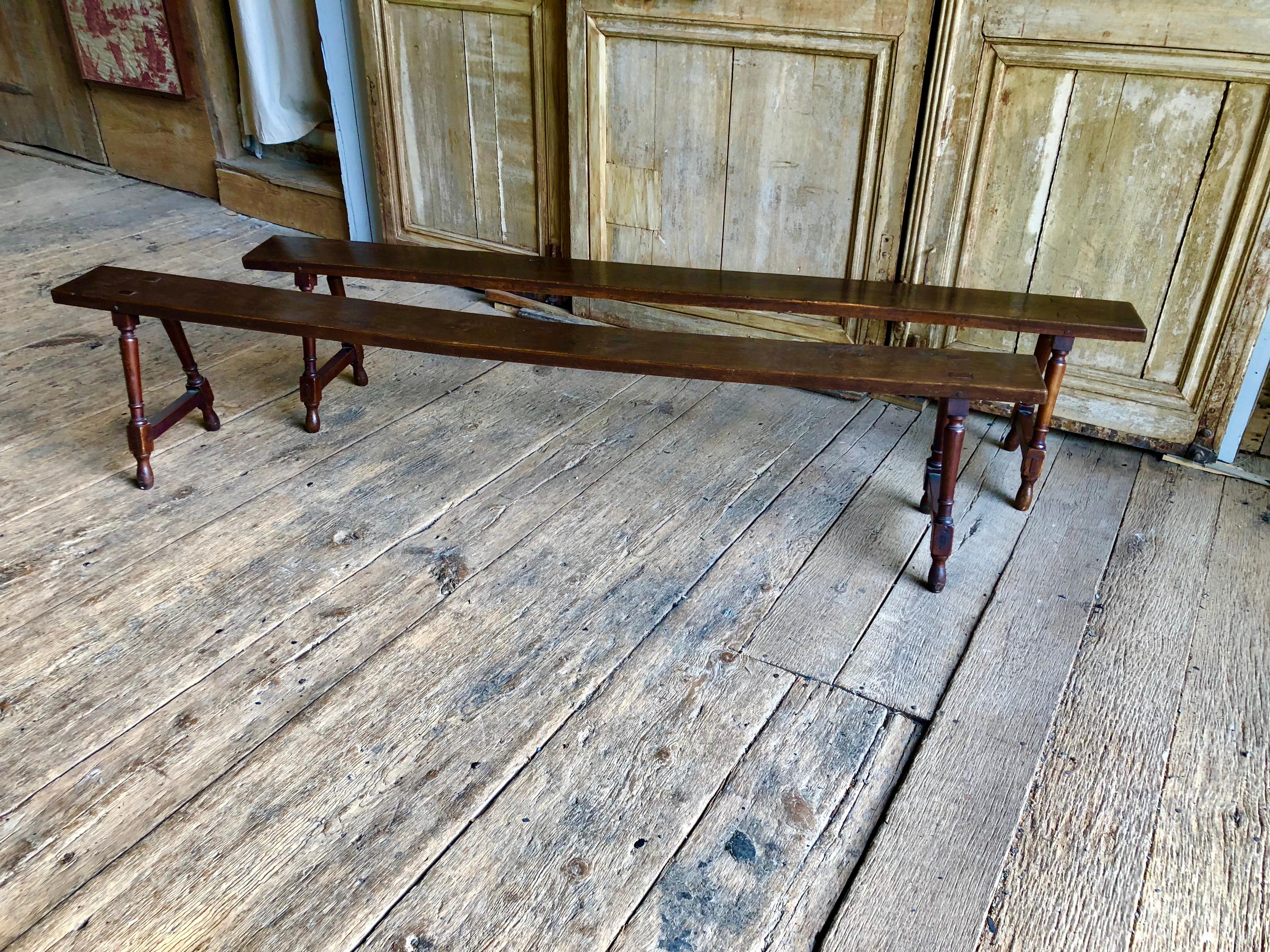 A pair of country benches in oak and cherry, with mortise and Tenon construction, with splayed turned legs, French, early 19th century.