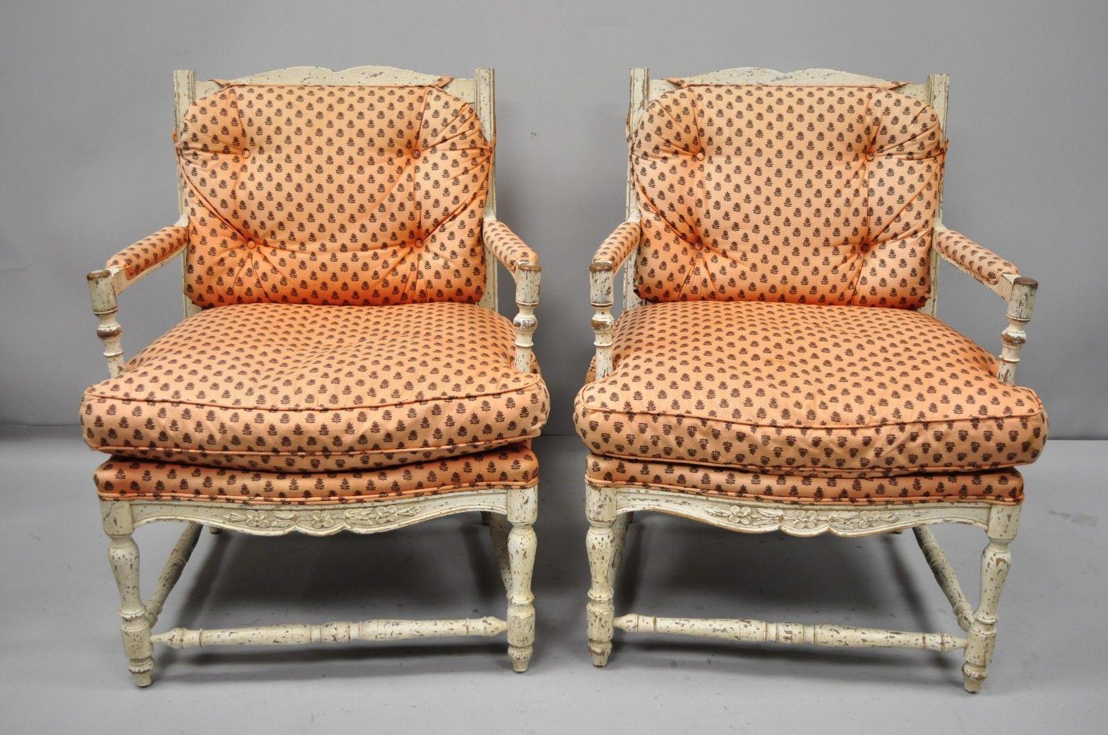 Pair French country cream distress painted lounge chair ladder back armchairs. Item features loose cushions, cream distress painted frames, stretcher supports, ladder backs, solid wood construction, great style and form, mid-20th century.