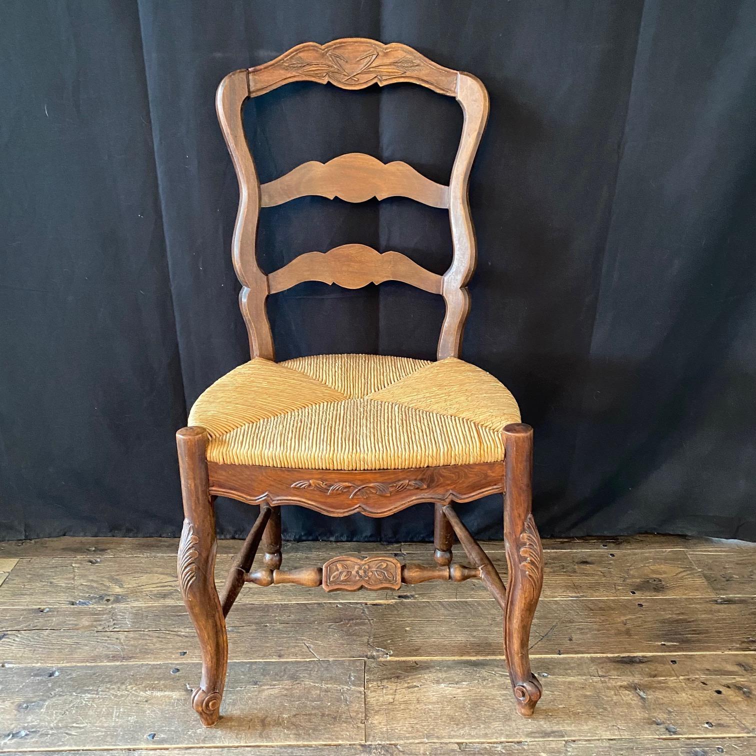 A lovely pair of French country Louis XV style dining chairs, each with sturdy walnut frame and natural rush seat. Lovely carving. #5870.