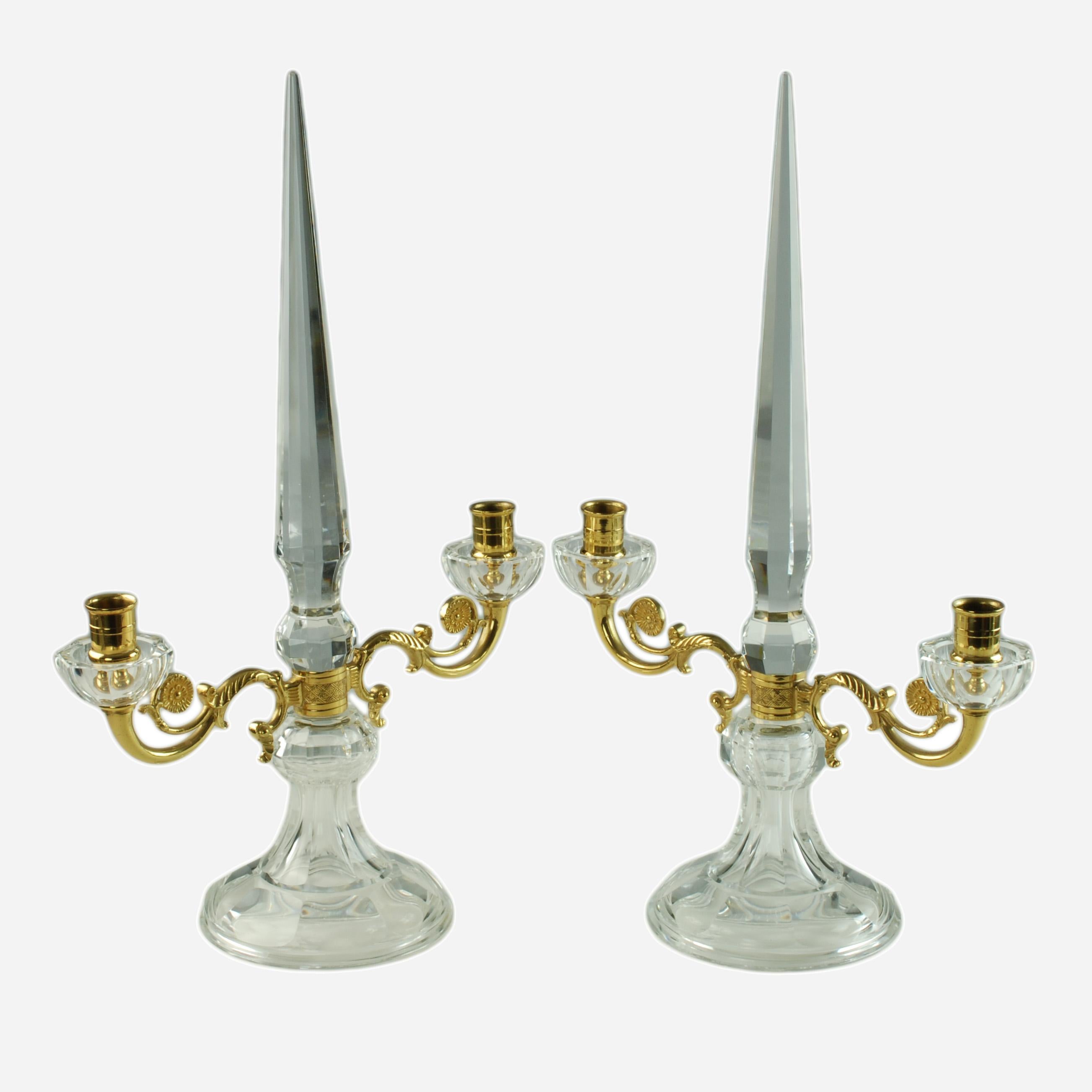 This graceful pair of French crystal candelabra features tall, tapered spike-form finials with panelled sides. The pieces have scrolling bronze doré arms finished with disc shaped accents decorated with embossed foliate detail best seen in image 8.