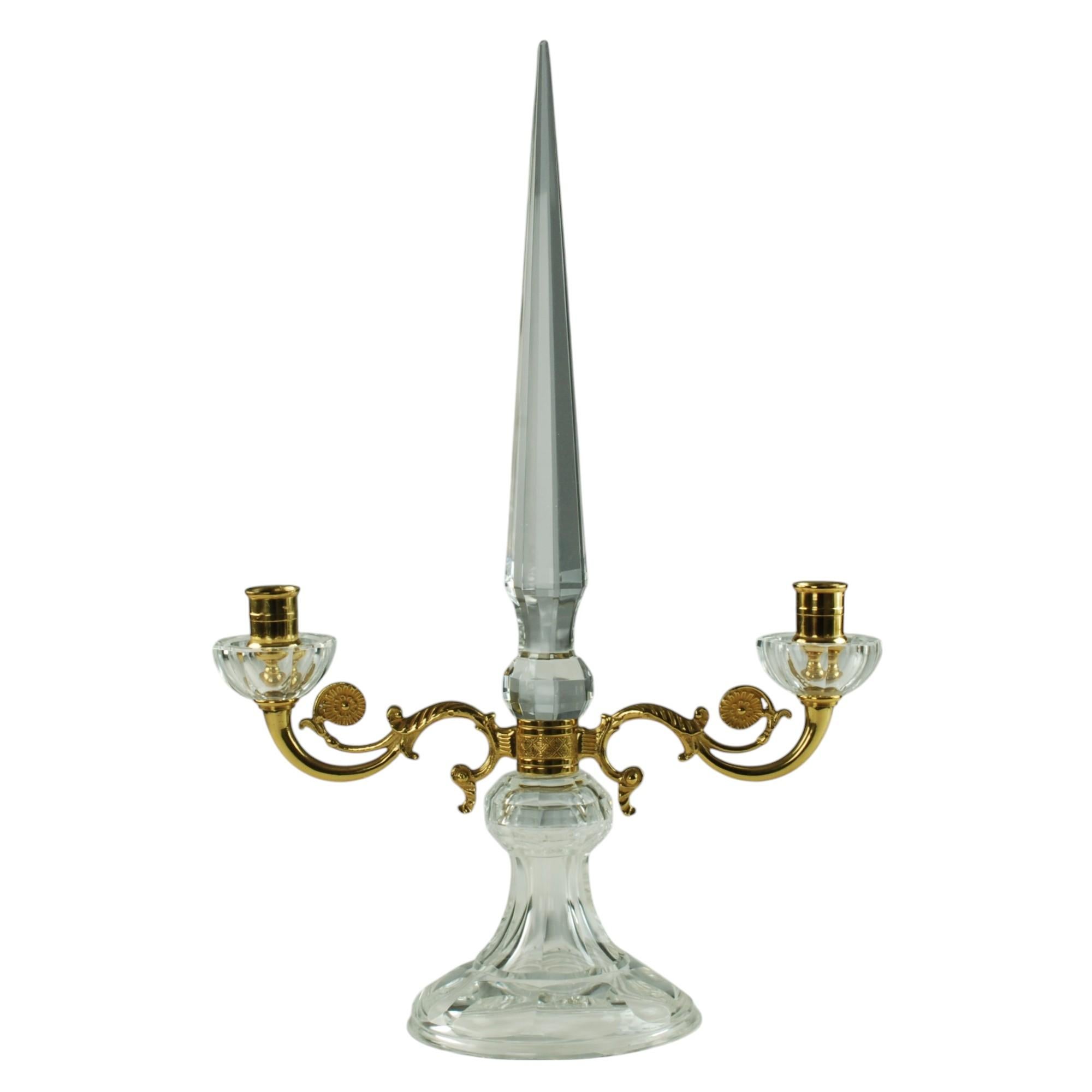 This graceful pair of French crystal candelabra features tall, tapered spike-form finials with paneled sides. The pieces have scrolling bronze doré arms finished with disc shaped accents decorated with embossed foliate detail best seen in image 8.