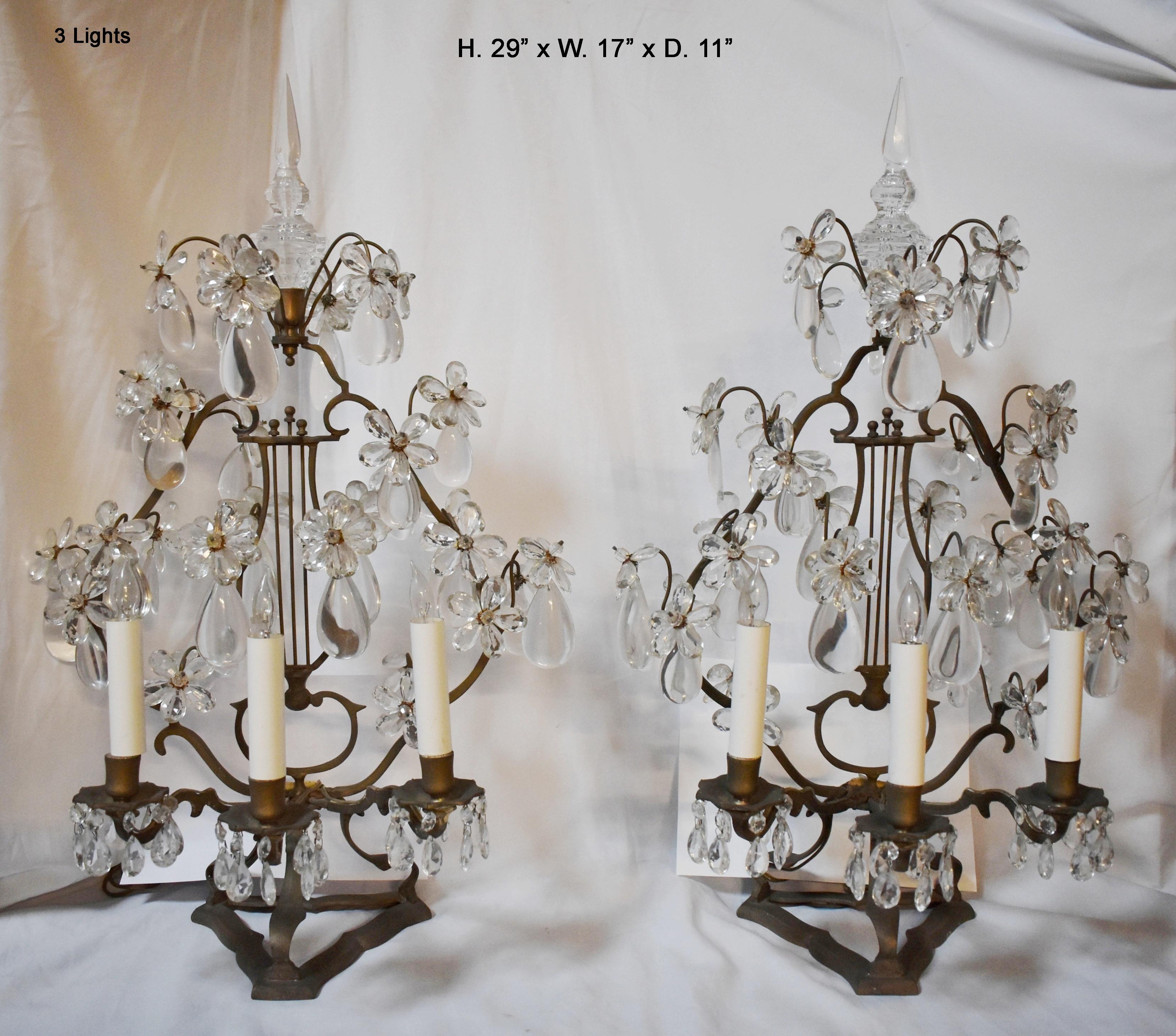 Lovely pair of 19 century French cut crystal and bronze girandoles.
Each girandole is surmounted with a faceted crystal finial, above a bronze lyre flanked by two supports, all adorned with various hand-carved and polished Rock crystal prisms, over