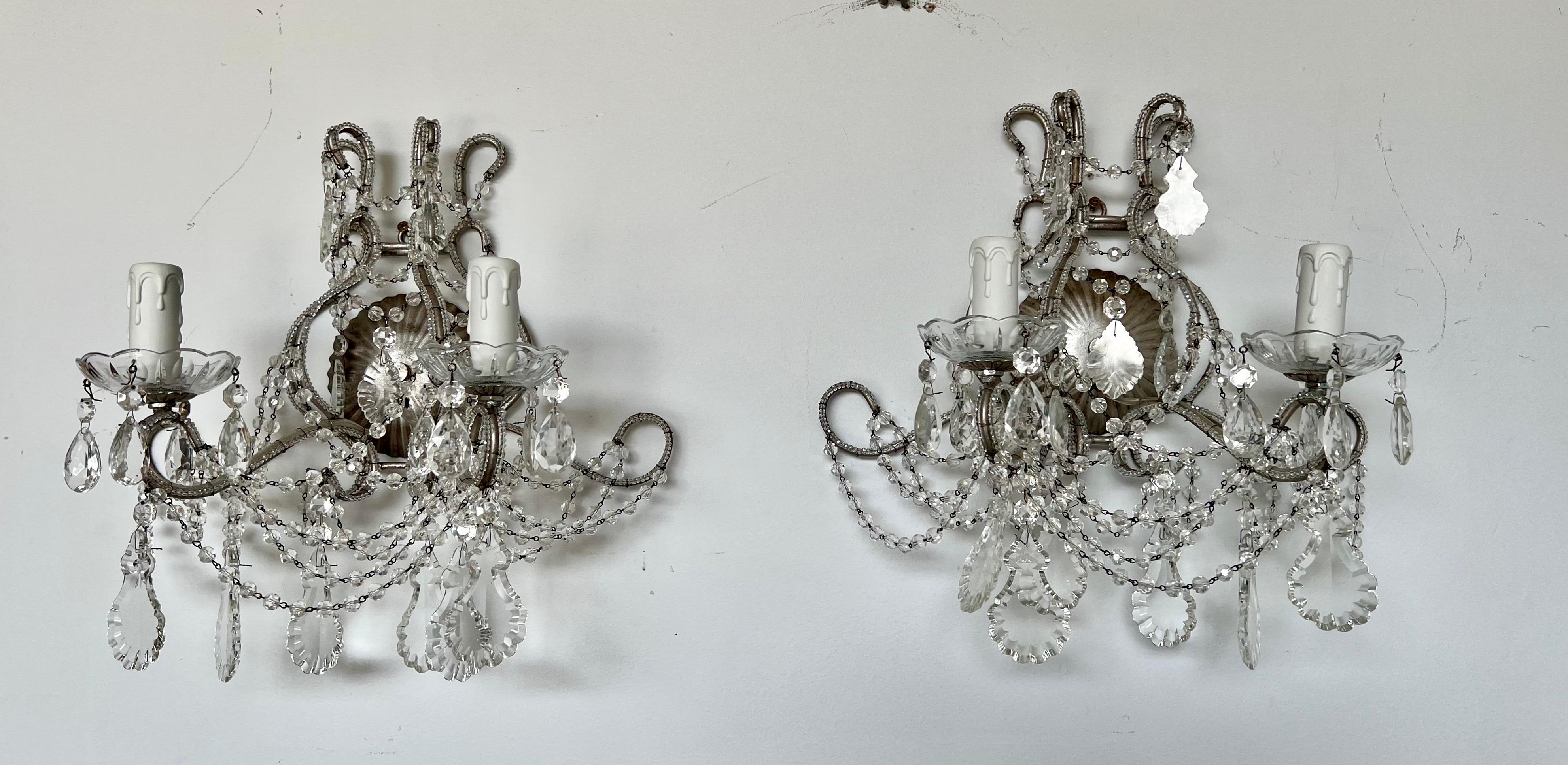 Pair of 20th century crystal beaded 2-arm sconces adorned with beautiful cut crystal & beads throughout. The sconces are silver gilt metal and are newly rewired with new candle covers. Ready to install.