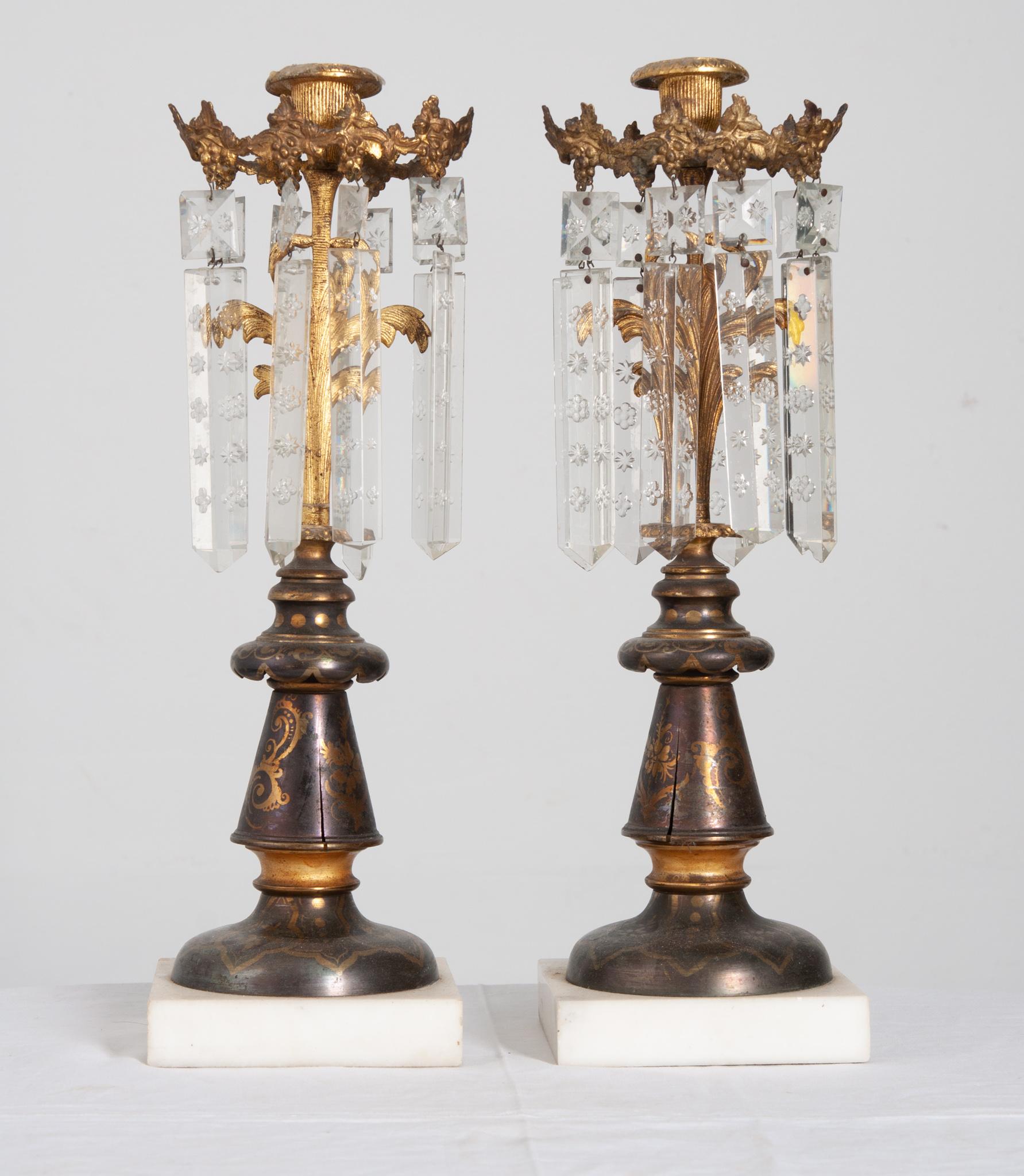 A stunning pair of metal candlestick holders with cut crystal drops and marble bases. The candle cups still have remnants of candles melted long ago. A gorgeous grape vine ring encircles the top and supports the crystal drops. Wonderfully detailed