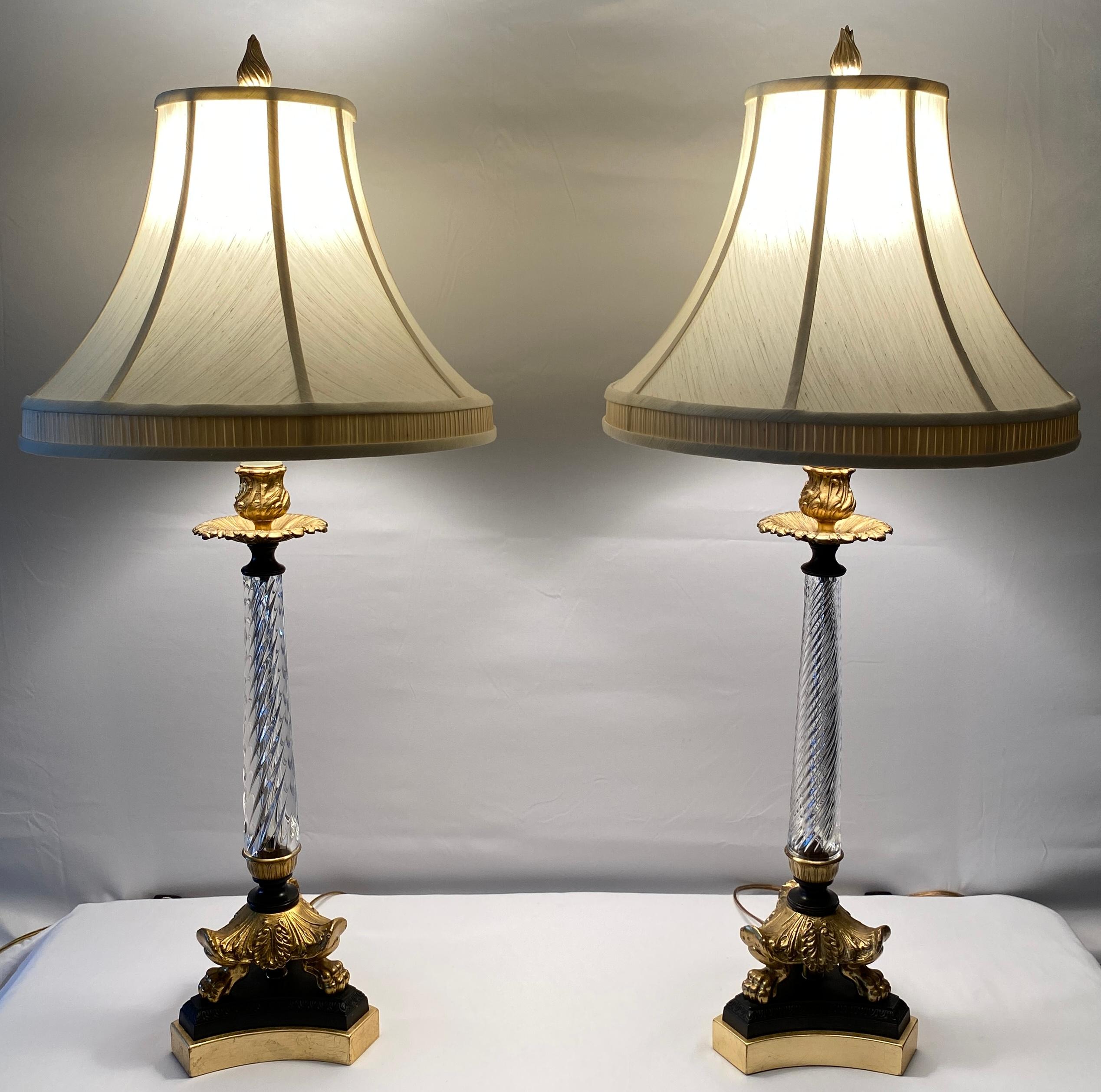 A pair of crystal table lamps, giltwood element wired for electricity, and fitted with two new sockets each.

Rope-twist motif complete with cut crystal reservoir mounted in finely chiselled bronze with claw feet designs further accentuated with