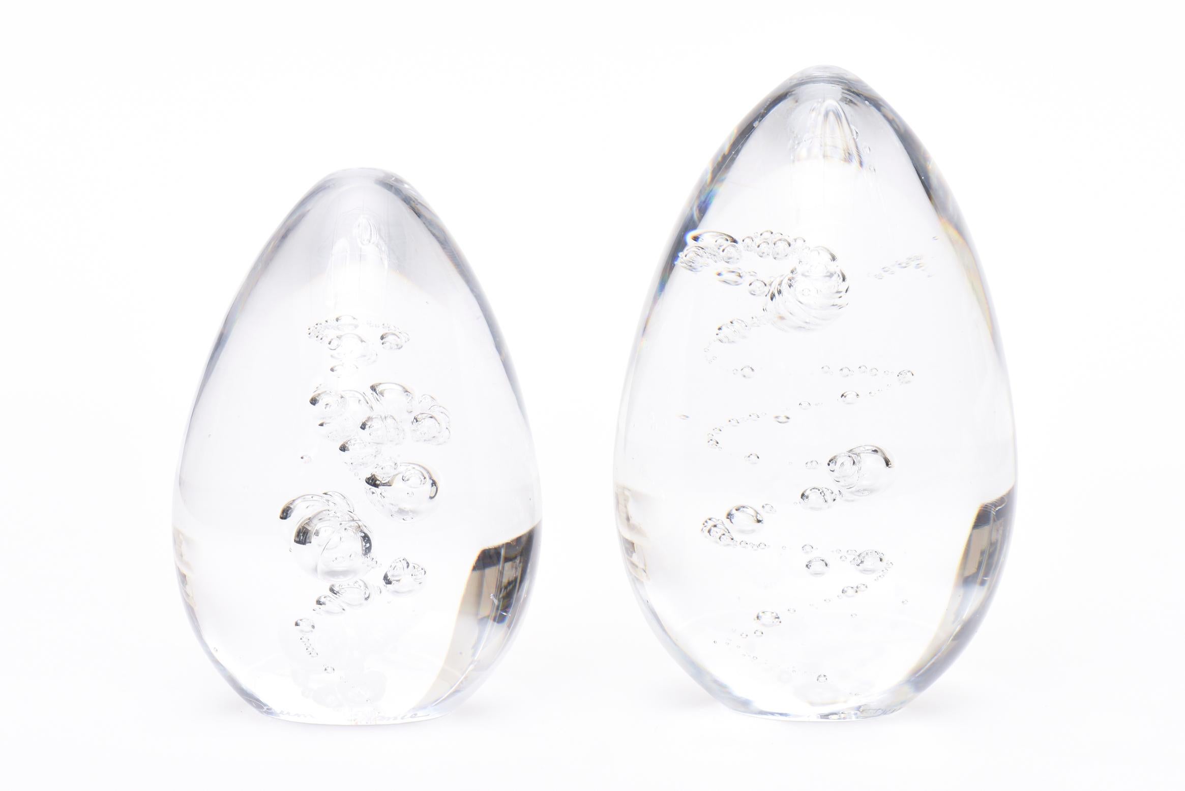 This pair of vintage French Daum signed crystal clear glass paperweights have bubble inclusions inside that are of a sculptural form. They are signed Daum France. They are two different sizes and make a great desk accessory the largest size is