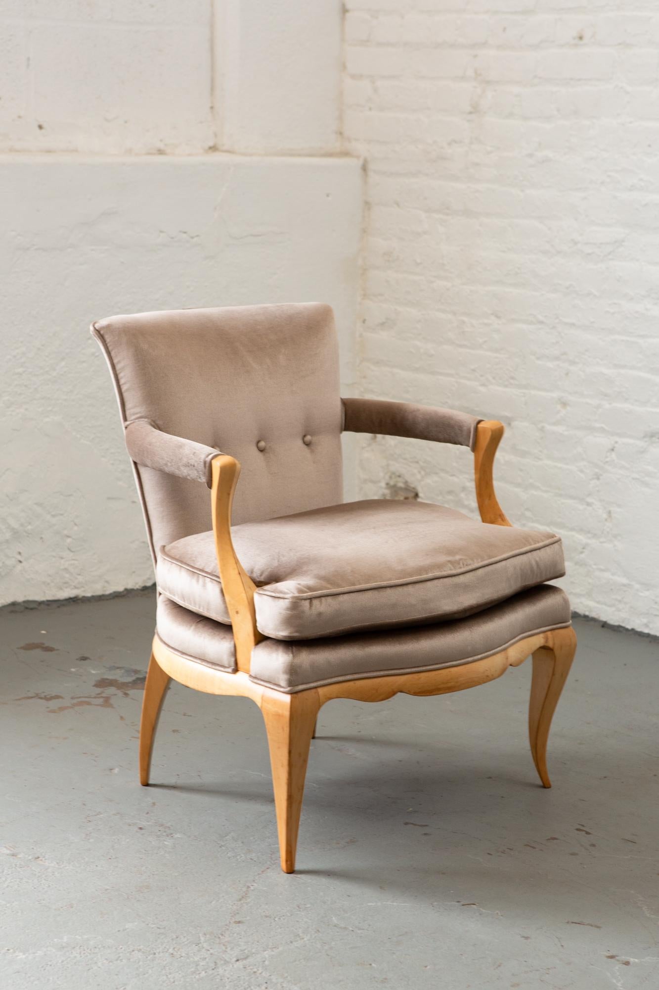 Newly upholstered pair of button tufted French Art Deco armchairs in beautiful natural finish with tapered legs and curved arms. Arms have a very handsome angular detail and are very sturdy.