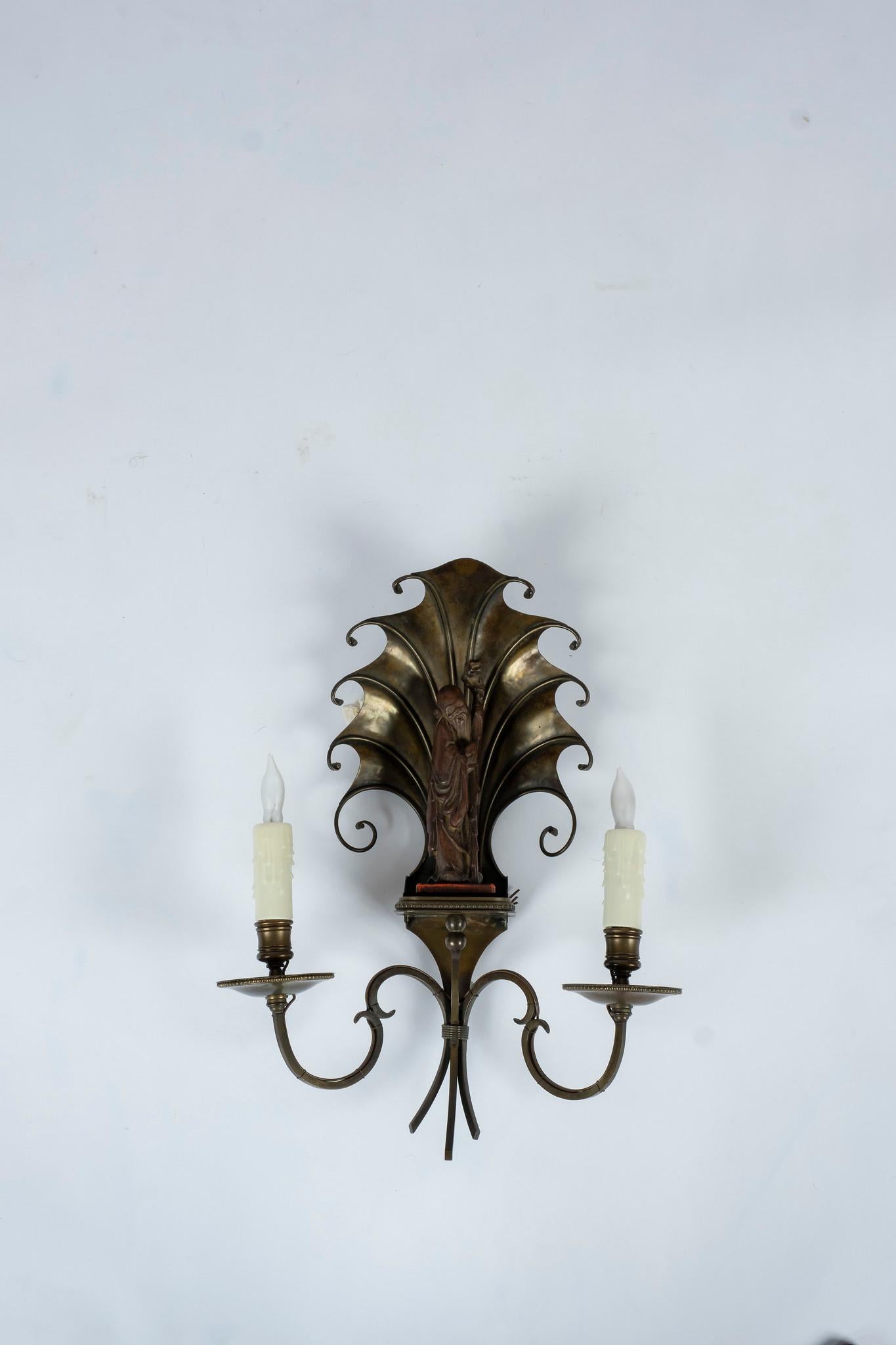 1940s French bronze and wood chinoiserie wall sconces. These feature two-light and hand carved wood scholars with deco shell cartouche, newly electrified with UL parts.
Measures: 17.5” H x 13” W x 6.5” D.