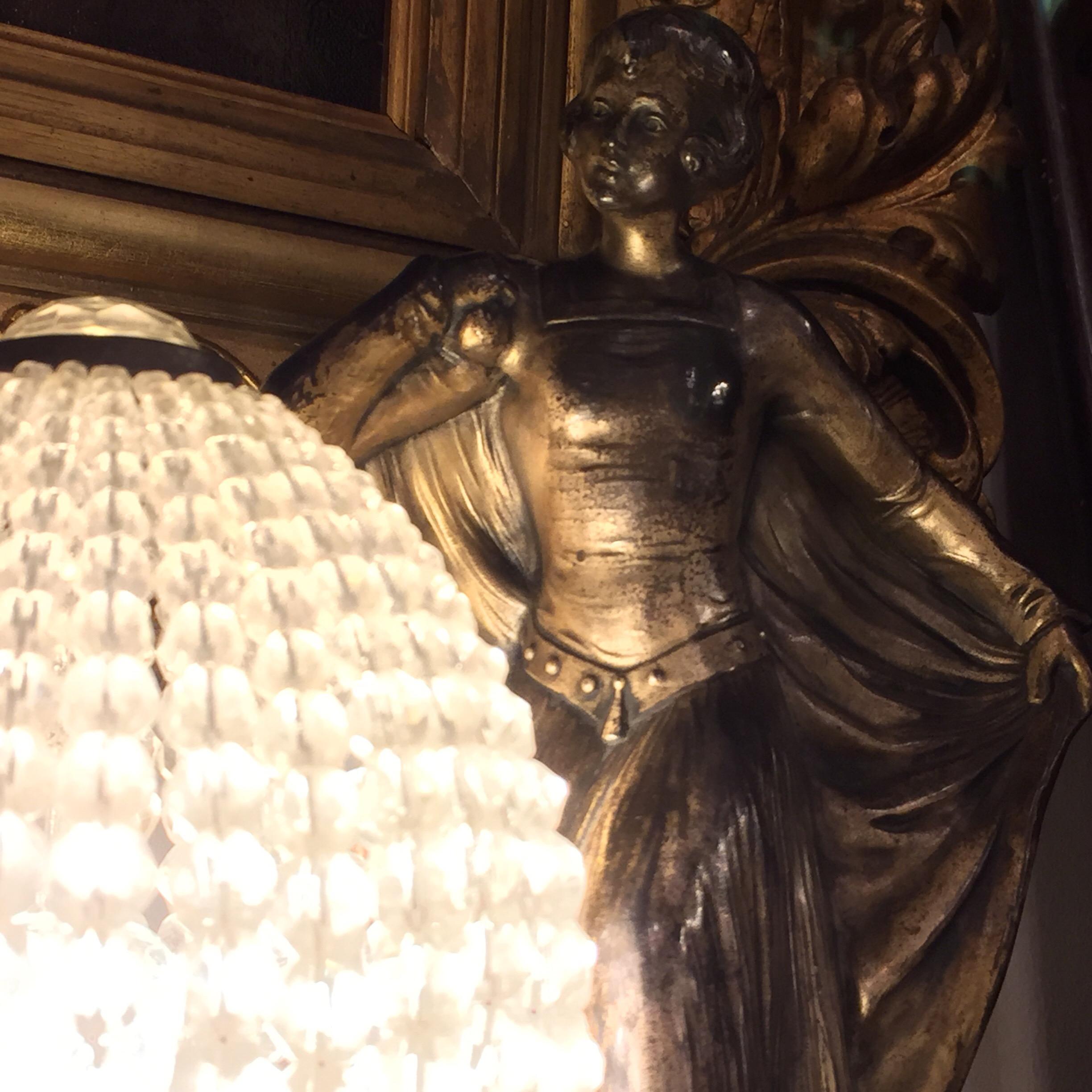 A pair of French Art Deco bedside table Lamps consisting of two elegant silvered cast metal female figures, standing on rectangular black marble bases, near a beaded crystal piriform lampshade creating  the perfect lighting atmosphere in your home.