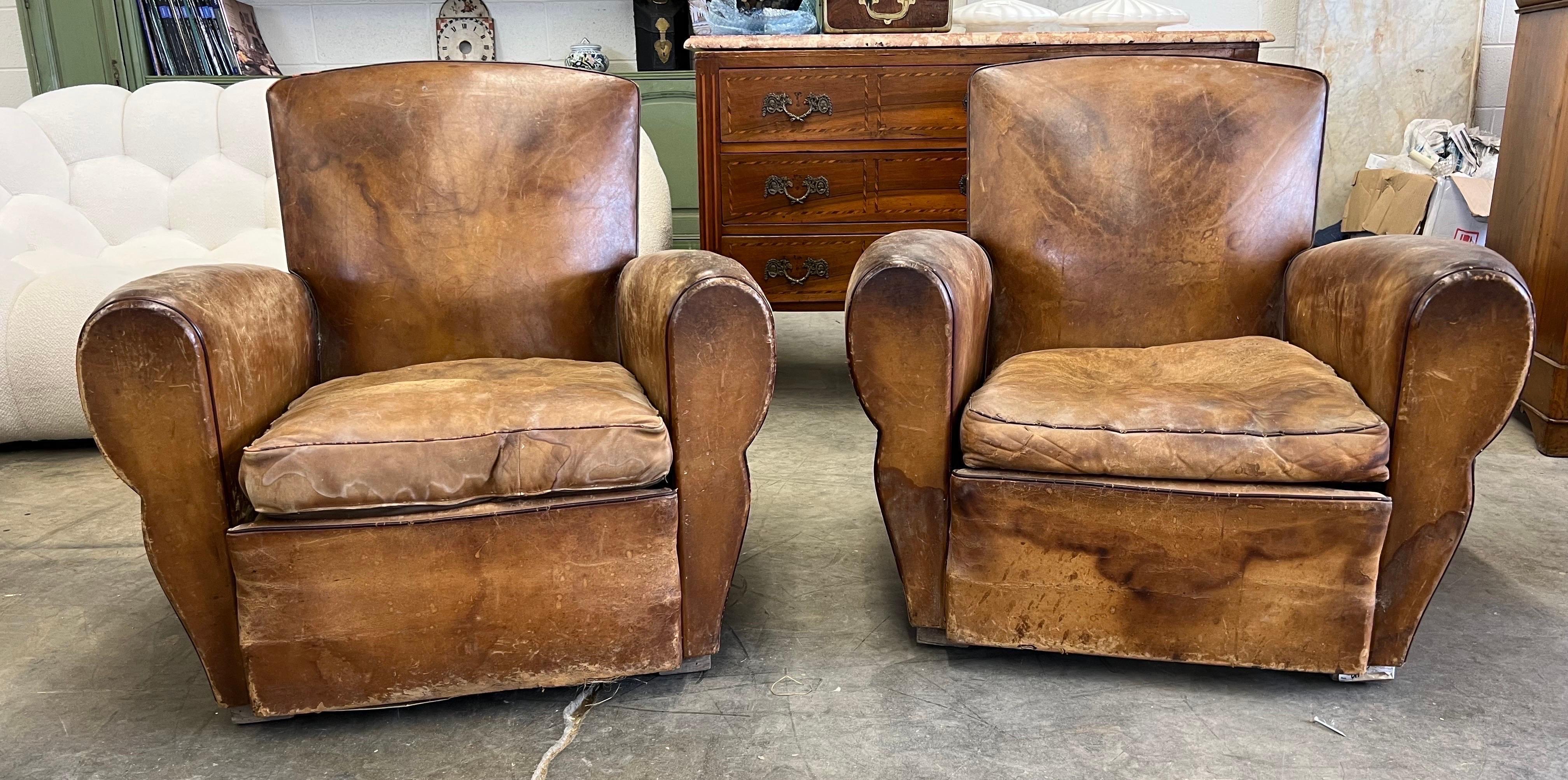 Great color and patina on this pair of French art deco period leather club chairs. Perfectly colored from years of use, yet no tears or rips with original loose cushions.