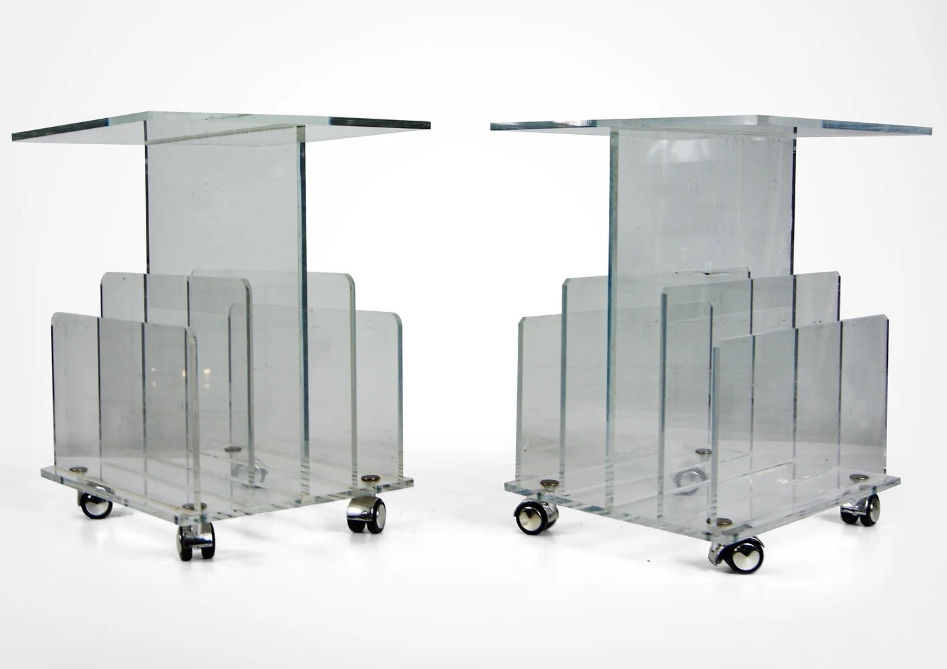 Pair of clear acrylic lucite side tables with magazine racks to the sides..circa late 1980s-France
Lovely multi-purpose decor, ideal for living large in small spaces.
The tables stand on chrome castor wheels.

In very good vintage condition and