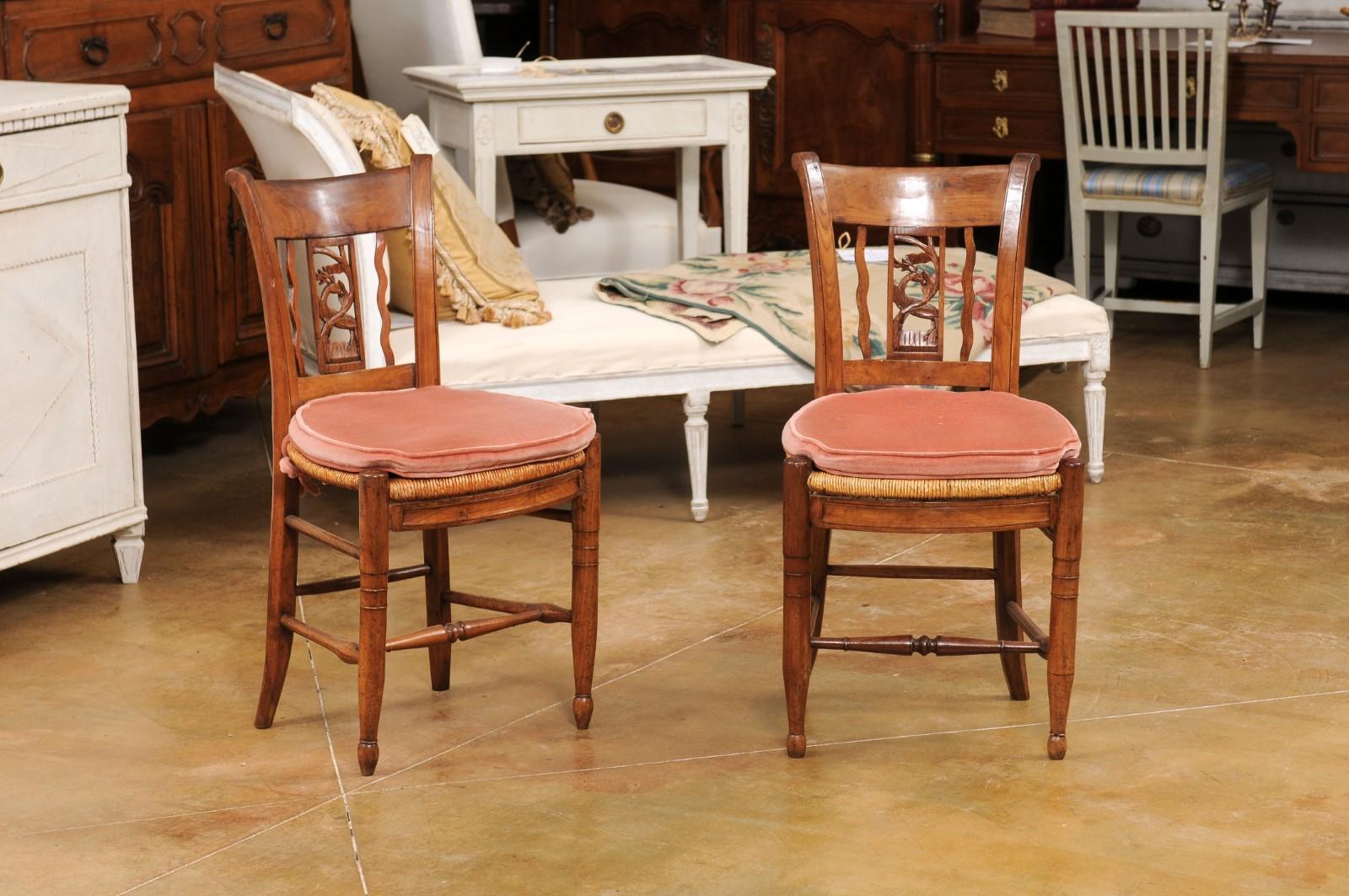 Paire de chaises d'appoint en noyer d'époque Directoire, datant du début du 19e siècle, avec dossier à enroulement, éclisses de cerf sculptées, sièges en jonc et petits coussins. Nous avons actuellement trois paires disponibles, vendues à 1 750
