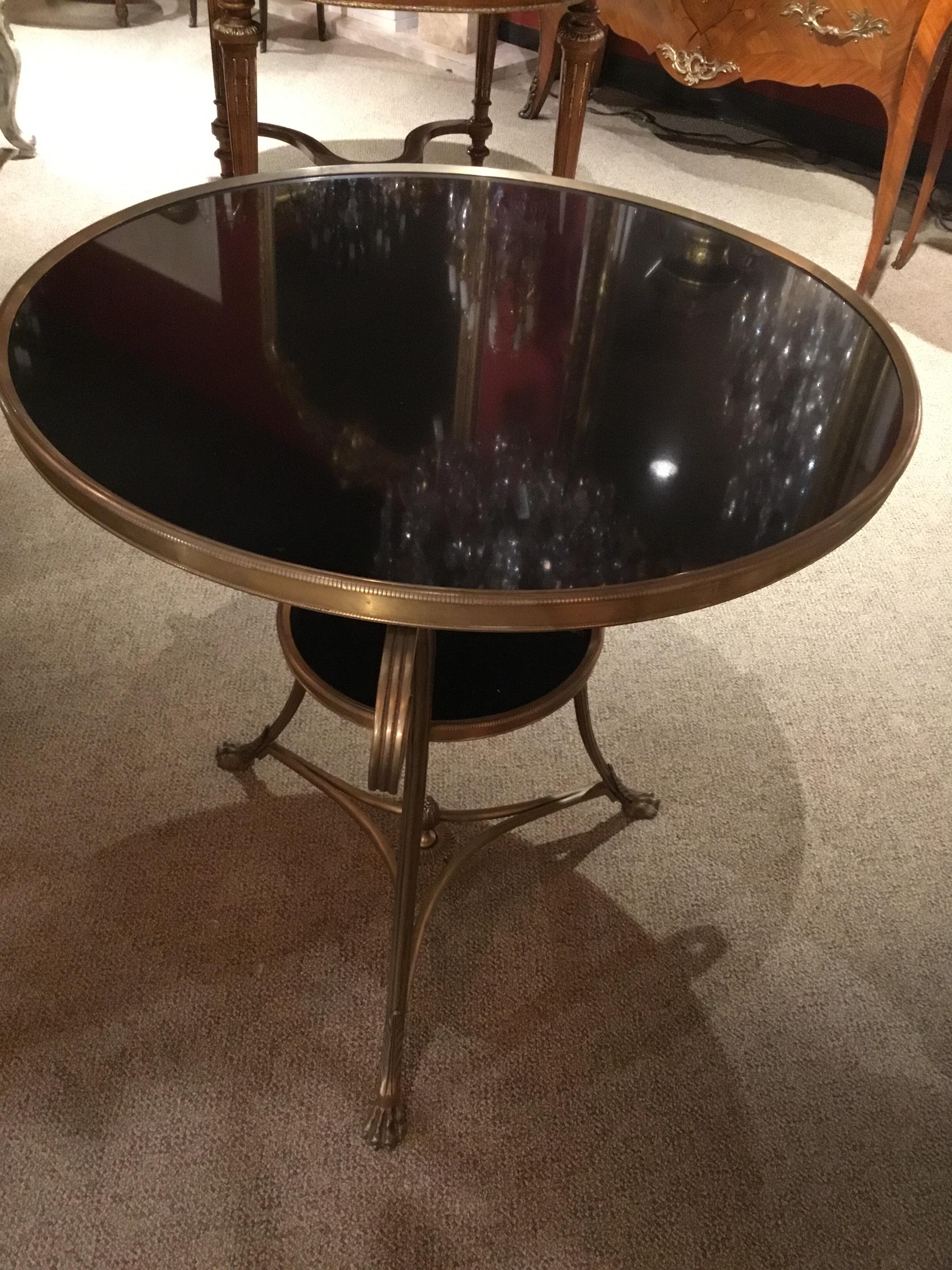 Pair of black marble top side tables with bronze molded edge, raised on
Three scrolled legs with a conforming lower shelf base stretcher with
A centered finial.