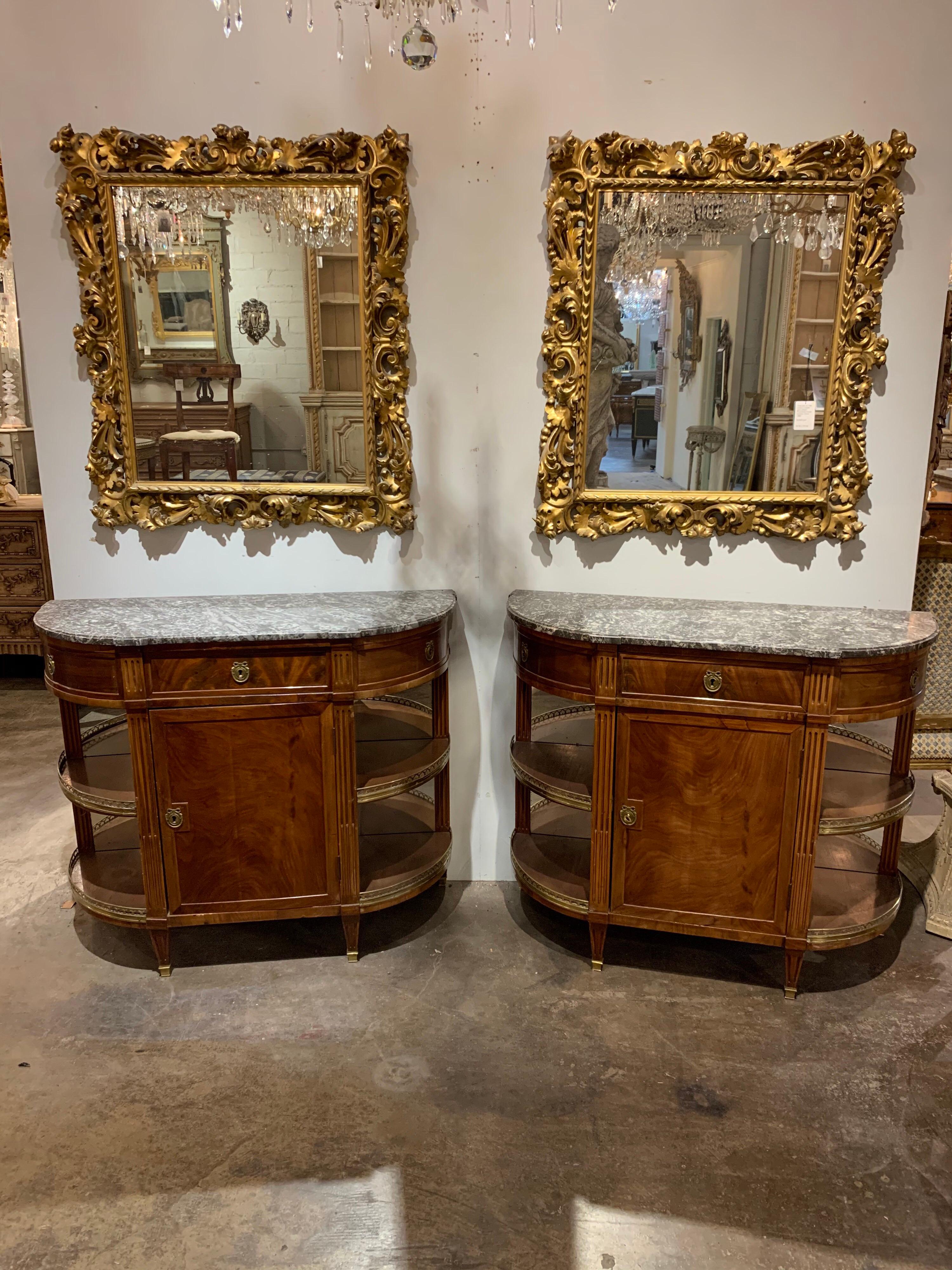 Lovely pair of French Directoire style mahogany servers with beautiful grey marble tops. Very fine rich tone on the wood. And the piece has nice mirrored shelves on the sides and more storage inside the cabinet as well. Functional as well as stylish!