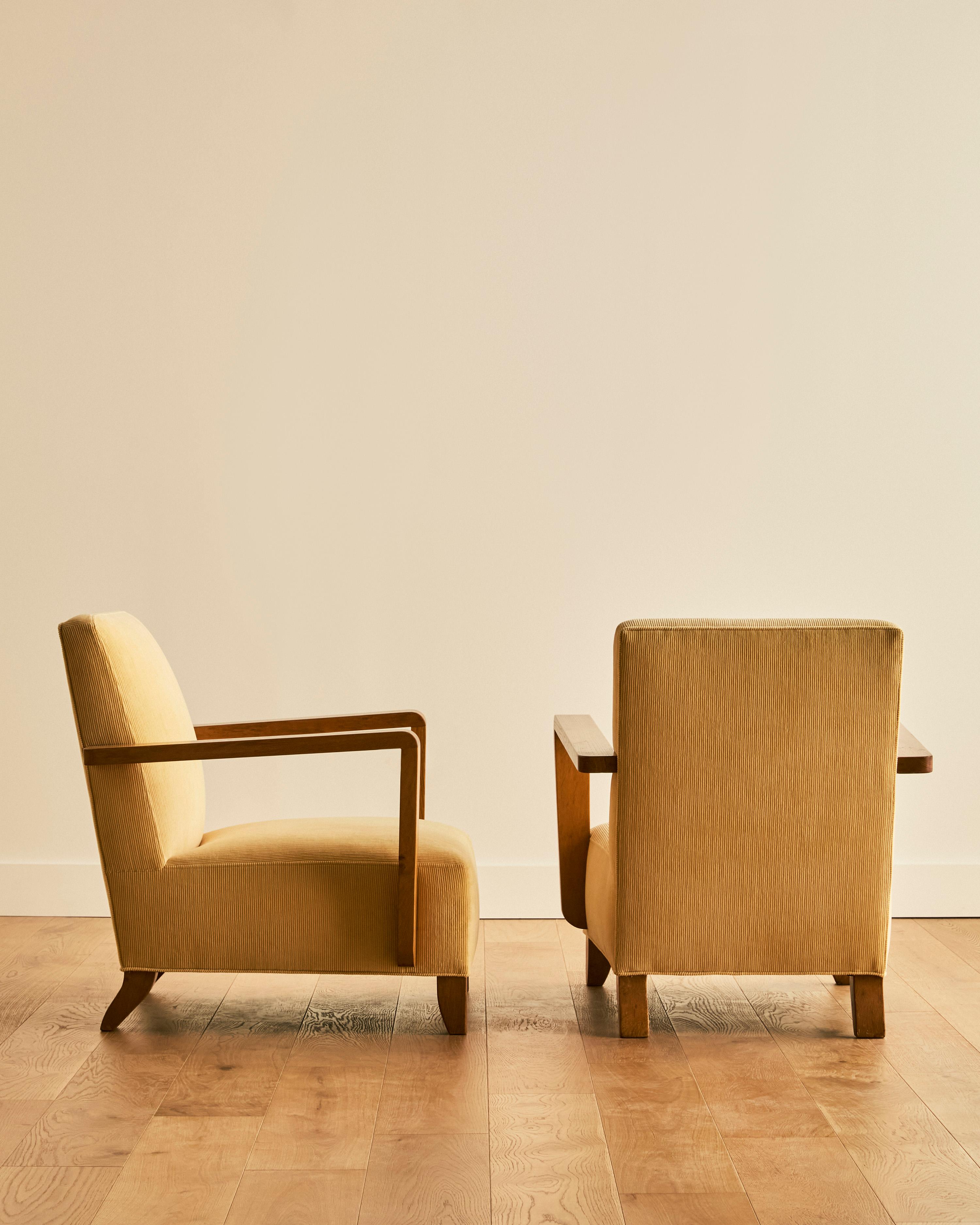 Paire de fauteuils club à accoudoirs ouverts Dominque avec pieds subtilement courbés C.I.C., retapissés en velours de coton souple jaune amande de Ralph Lauren.