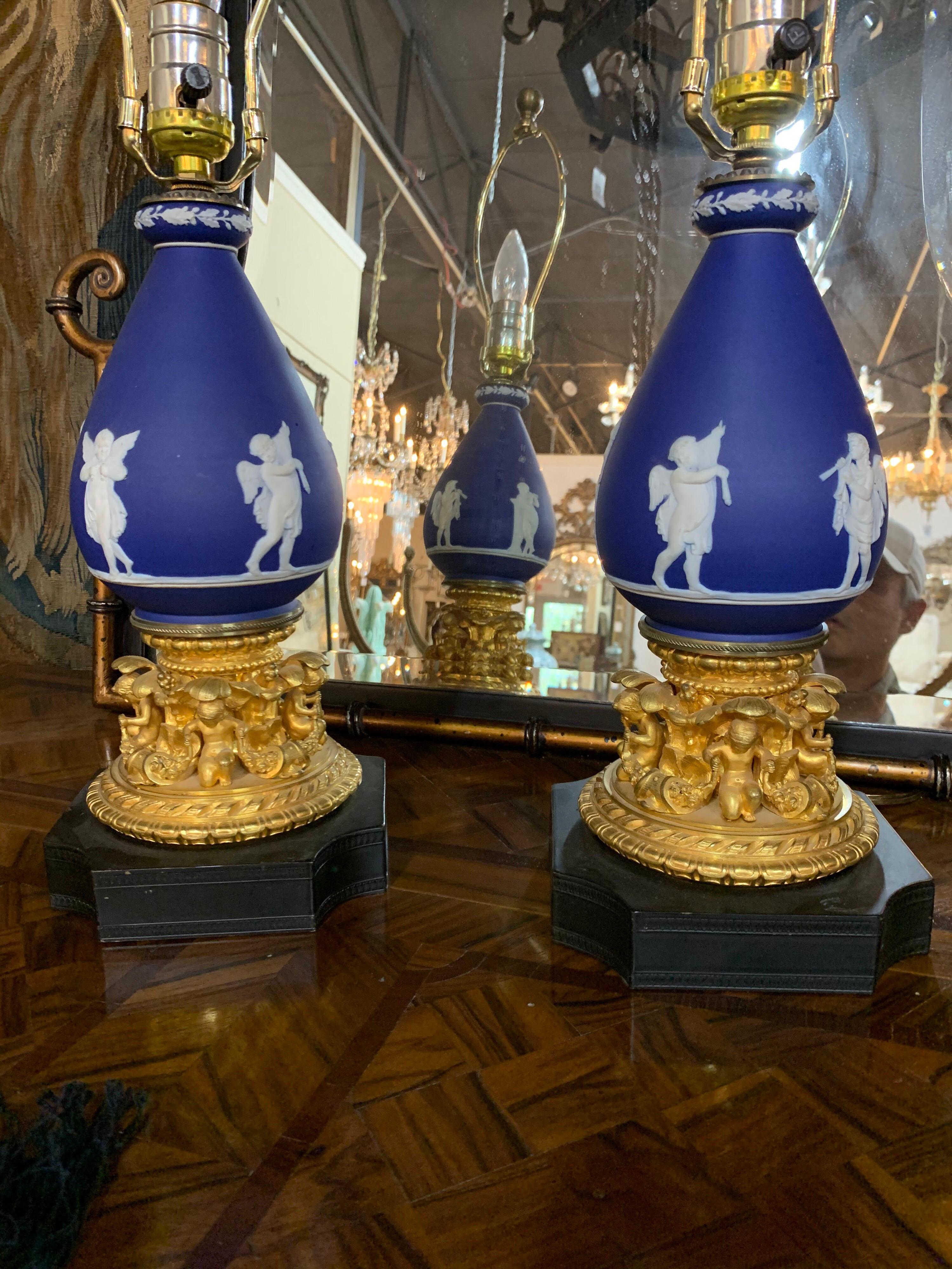 Stunning pair of French doré bronze and Wedgwood cherub form urns that have been made into lamps. Beautiful carvings of cherubs on the base of the lamps as well. These are very special!