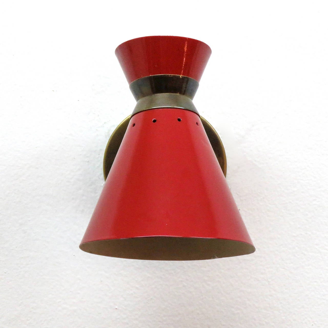 Elegant pair of French short stem double cone wall lights by Rene Mathieu in red enamel and brass, individual on and off switch. Rewired with original sockets, some wear to the interior enamel. One French socket per fixture, max. wattage 40w each,